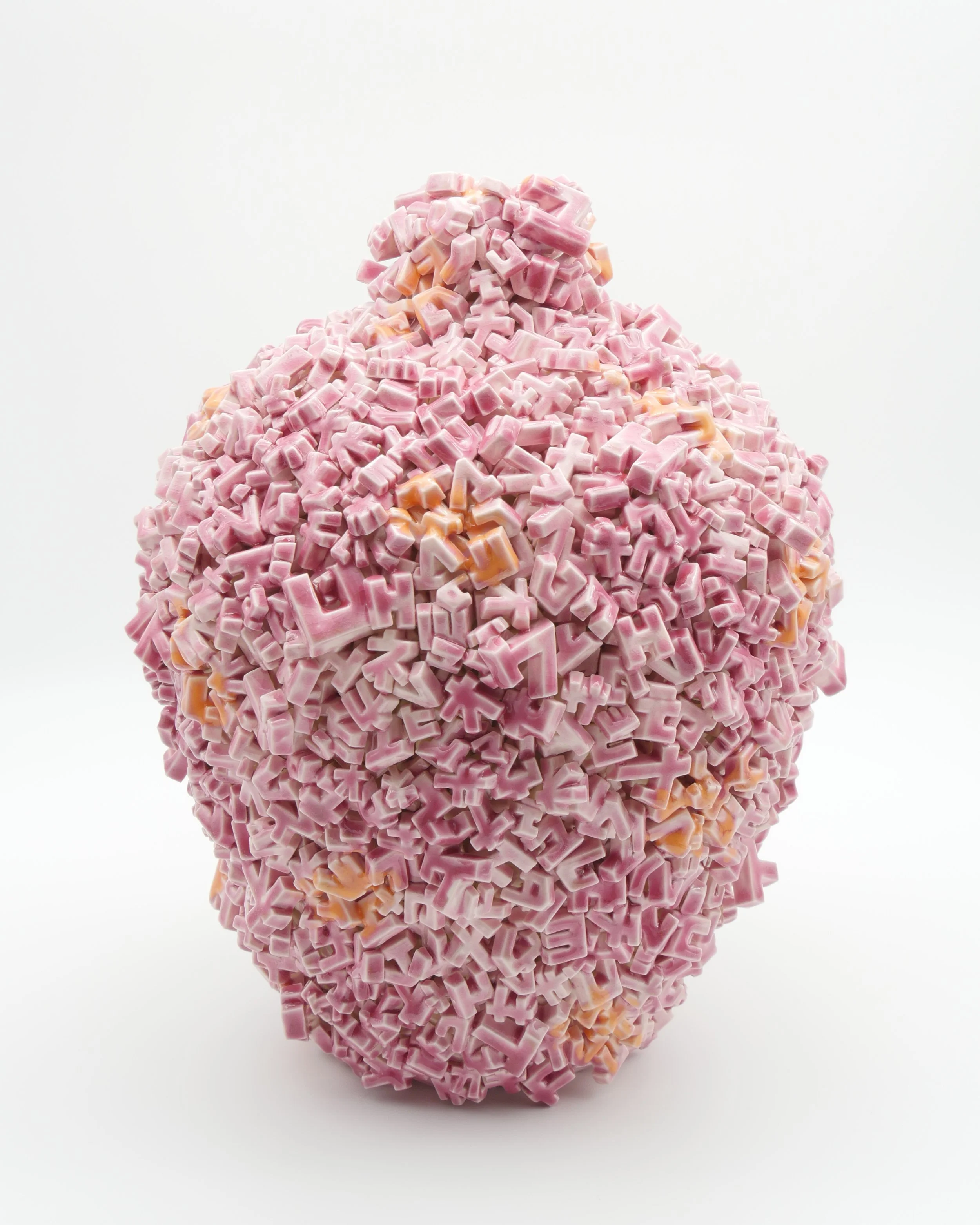 A large, oval-shaped sculpture made of pink and orange alphabet-shaped tiles arranged in a densely packed, textured surface.
