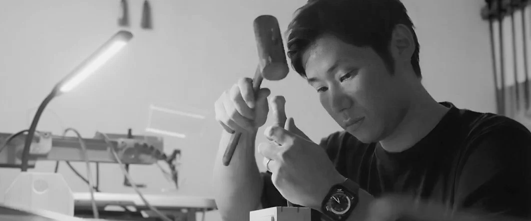 Kodawari. Oshima Kobo. Young man working with a hammer and chisel in a workshop.