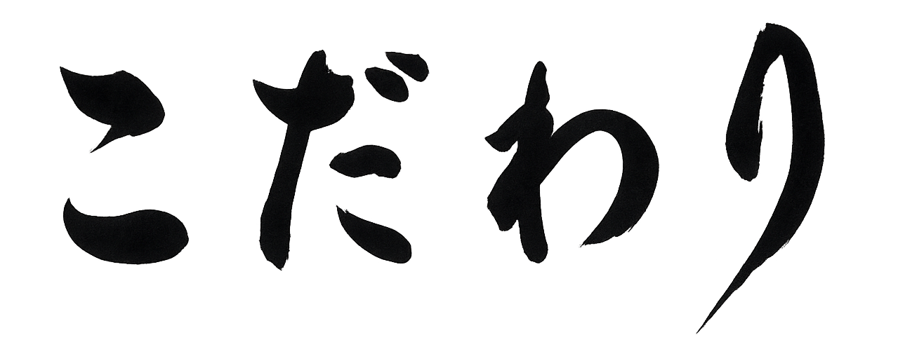 Kodawari. Black Japanese calligraphy characters on a white background.