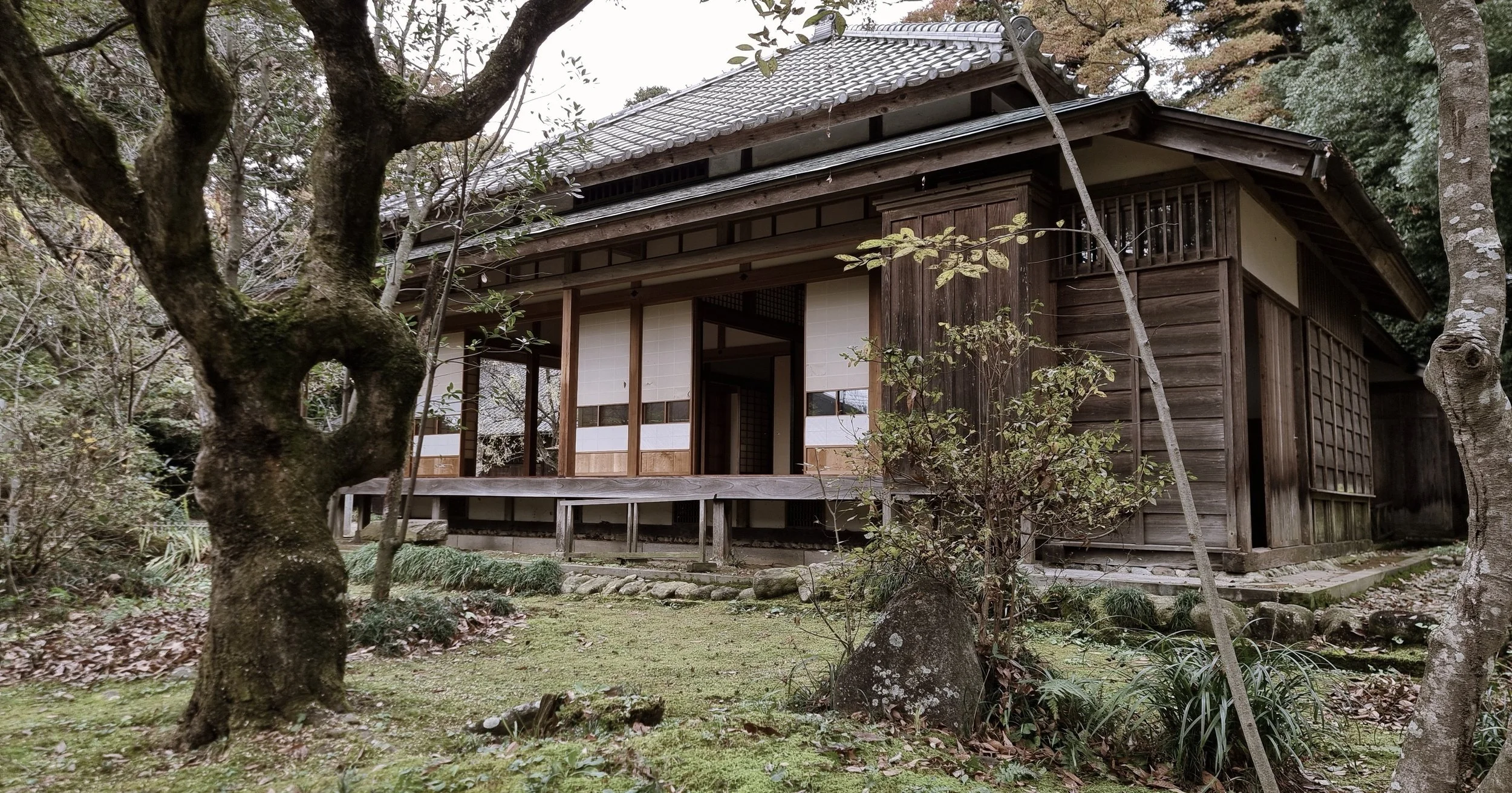 Kodawari. Traditional Japanese wooden house surrounded by trees and garden in autumn.