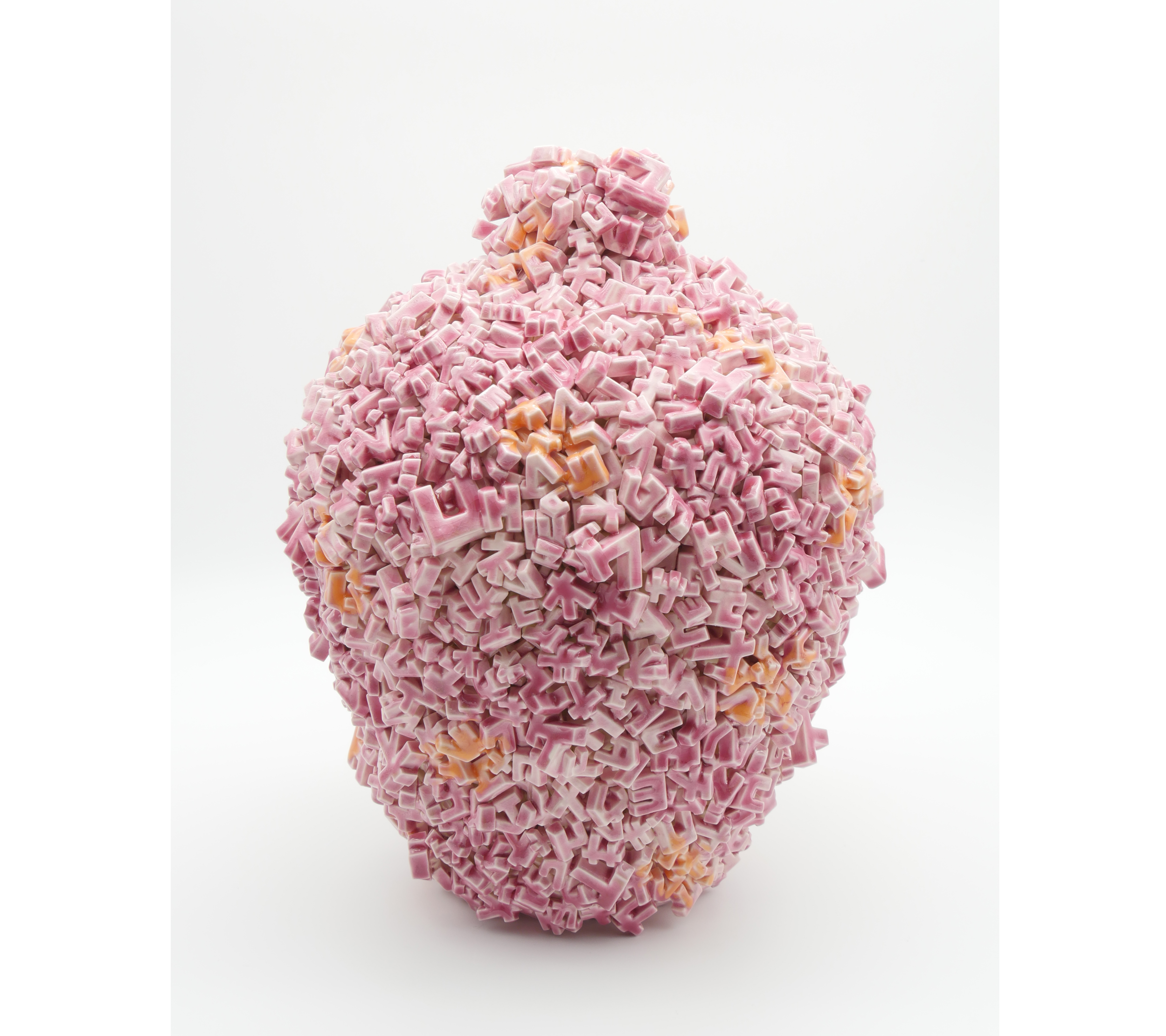 A large, oval-shaped sculpture made of pink and orange alphabet-shaped tiles arranged in a densely packed, textured surface.