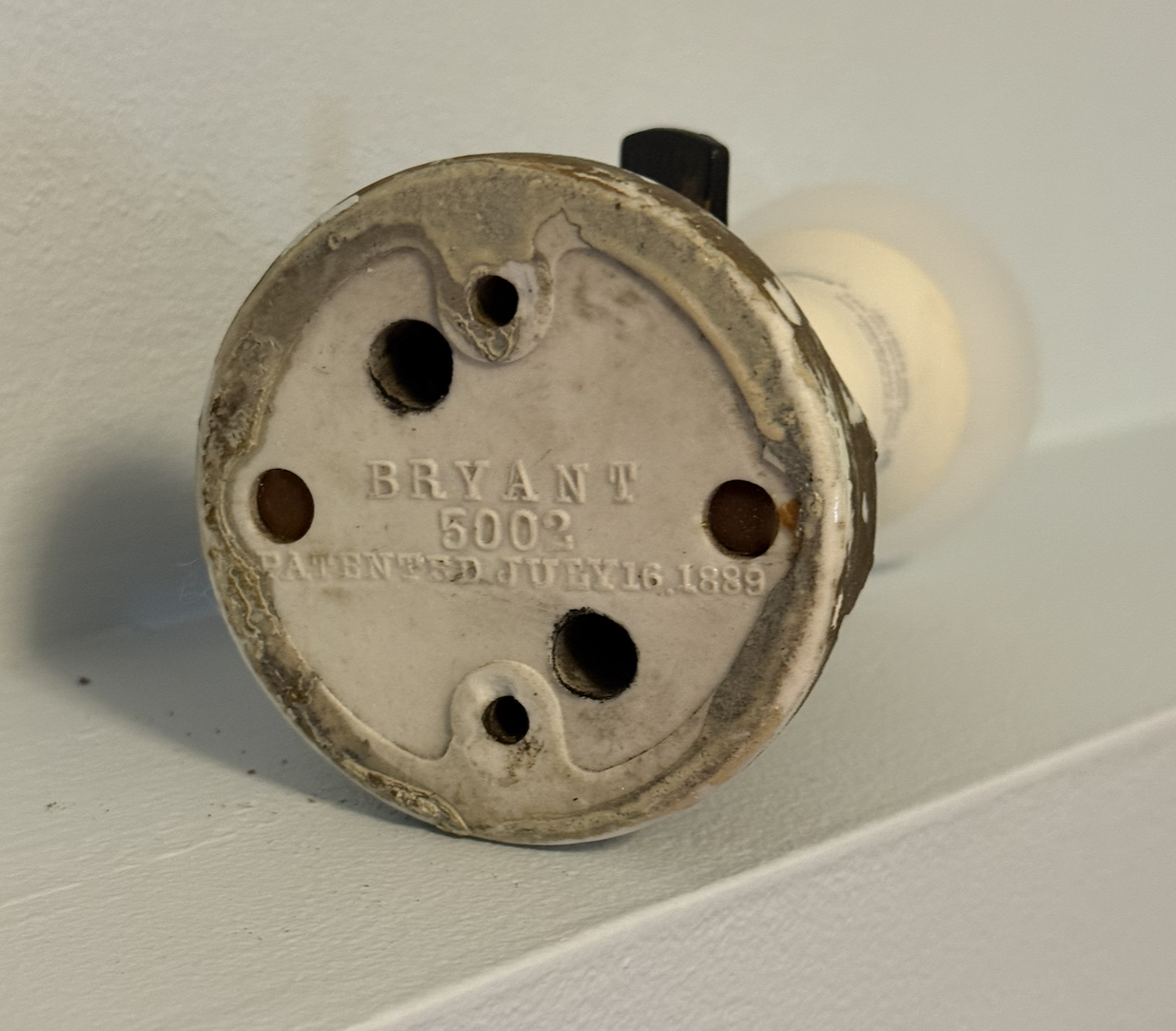 Patented in 1889, these heavy porcelain bases were designed to be screwed directly to the surface of a wall or ceiling beam