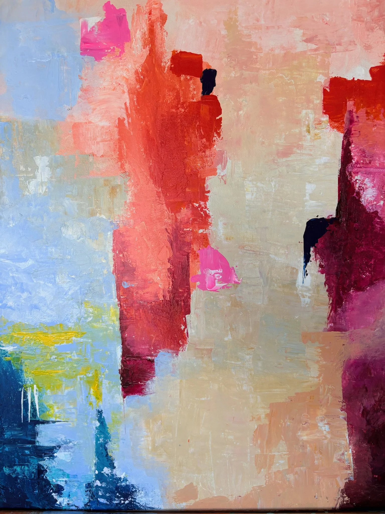 Colorful abstract painting on canvas with vivid coral, pink, and peach tones contrasted by cool blue and yellow, created with textured palette knife techniques.