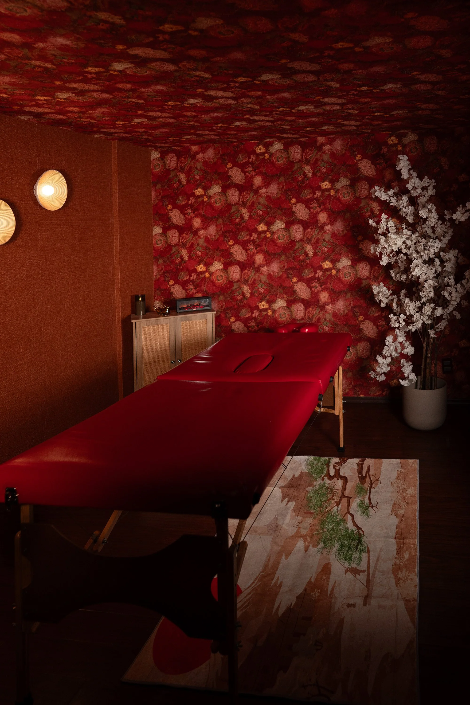 Boutique spa treatment room in Mexico with red interior design and massage table.