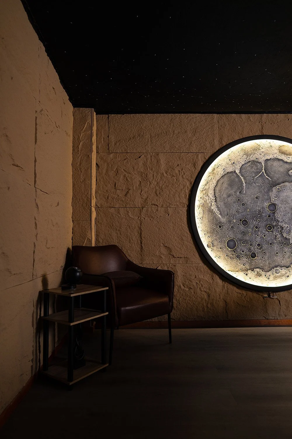 Immersive spa lounge in Mexico featuring a large illuminated moon installation and relaxation chair.