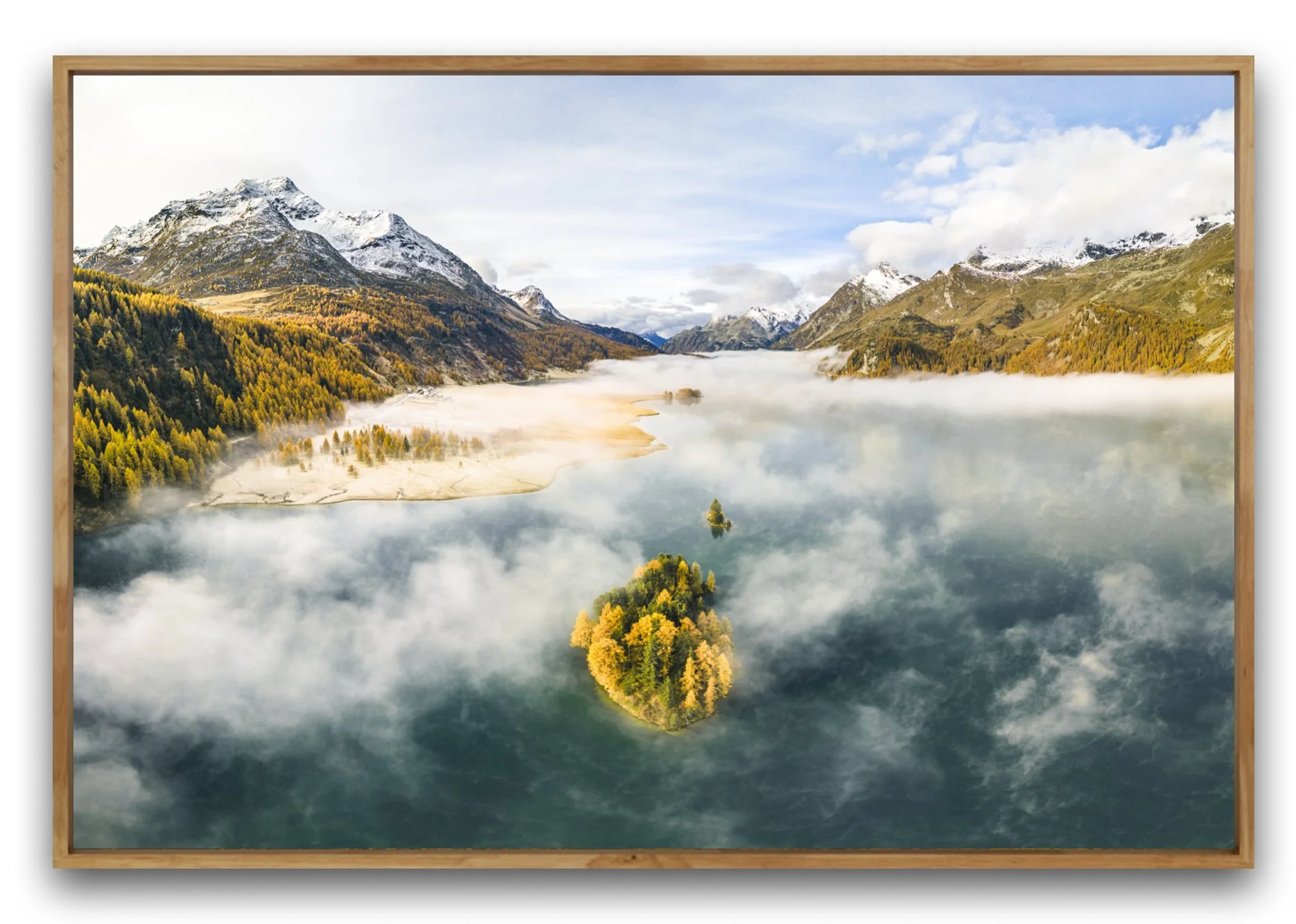 Landschaftsbild vom Silsersse im Engadin, Grabünden, Schweiz. Zu sehen ist die Insel Chaviolas und Piz da la Margna mit Bergsee umgeben von schneebedeckten Bergen und herbstlichen Bäumen; Nebel schwebt über dem Wasser, Insel mit Bäumen im Vordergrund