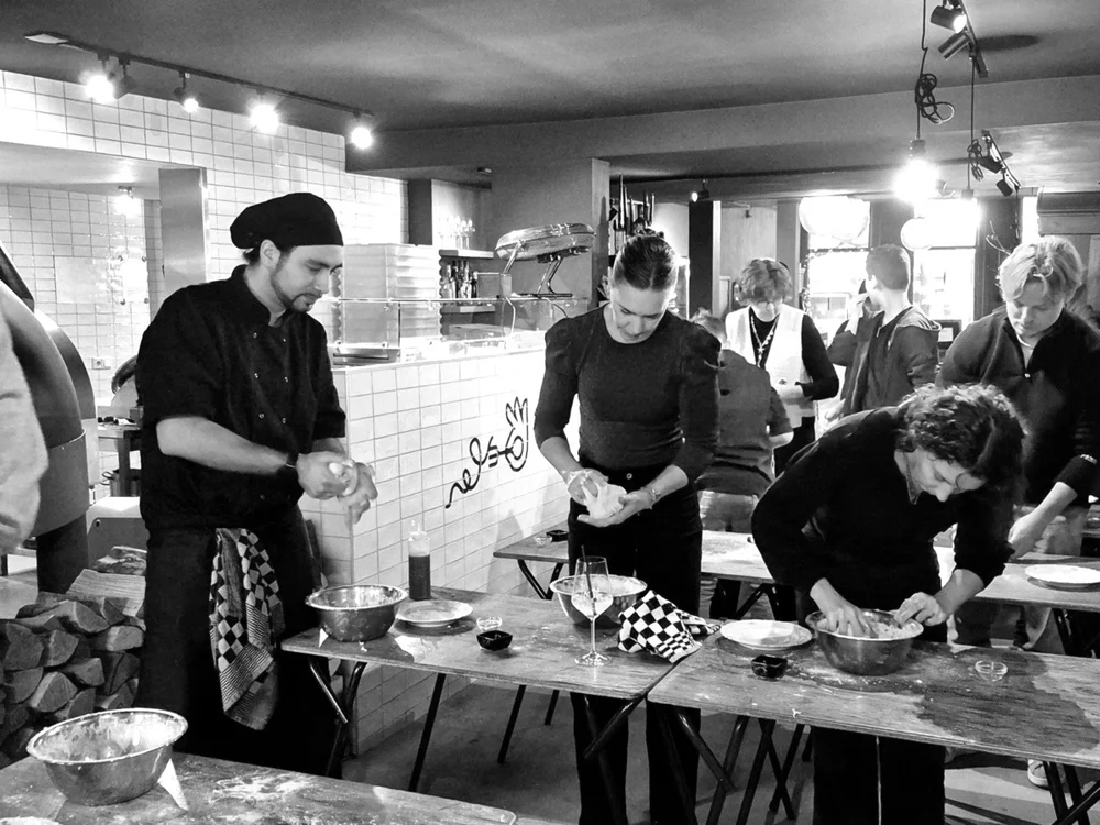 Mensen maken pizza tijdens een workshop bij Forchetta