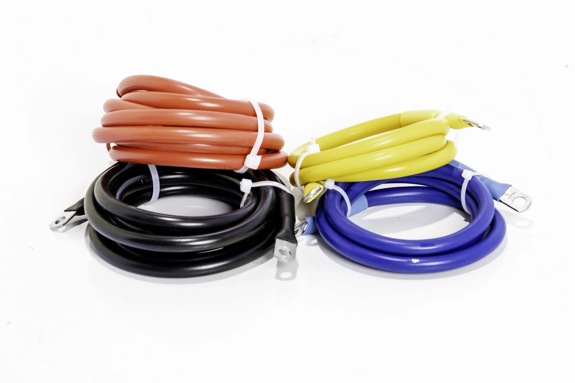 Assorted coiled cables in black, red, yellow, and blue, each with terminal ends.