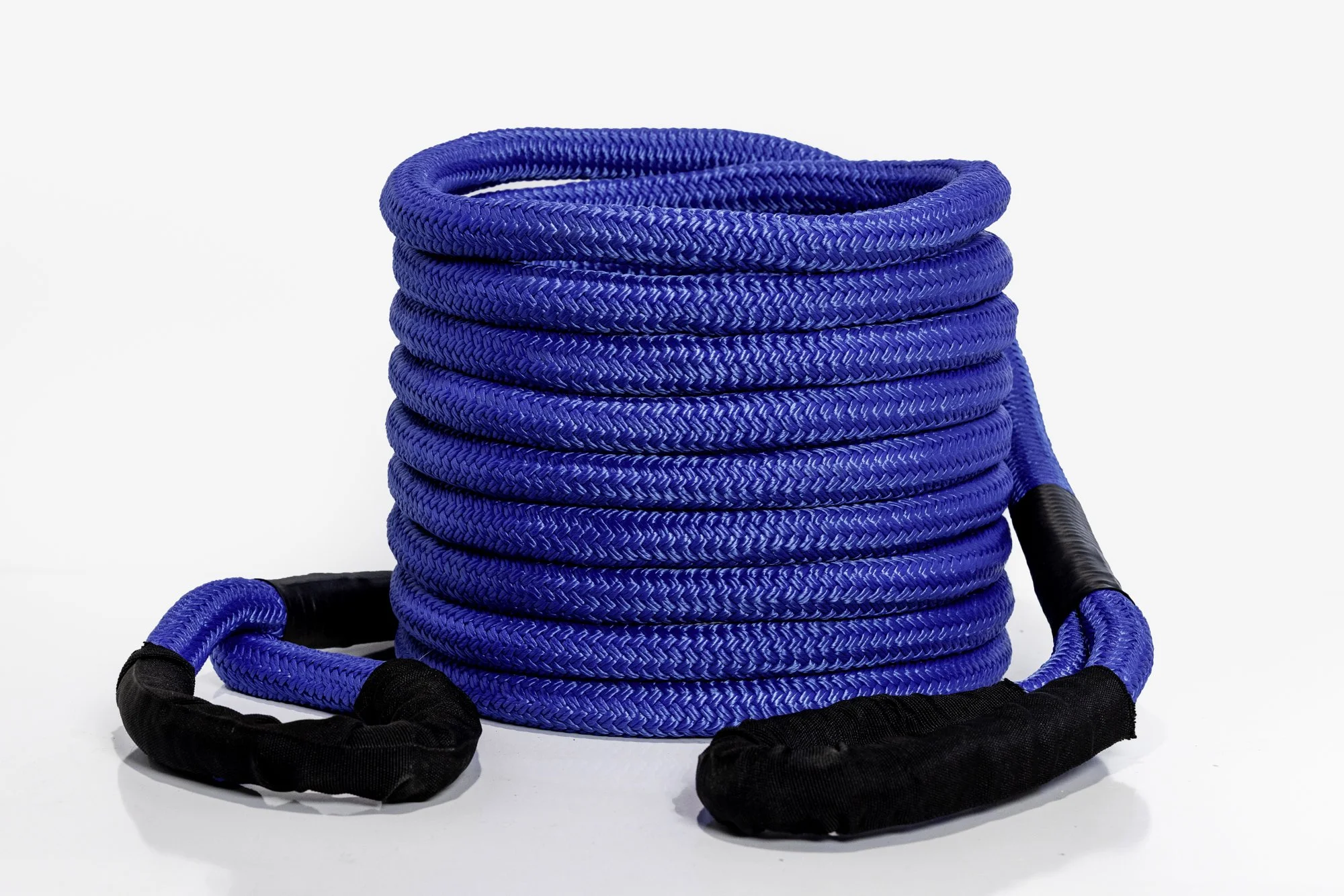 Blue braided rope coiled neatly, with black protective sleeves at the ends.
