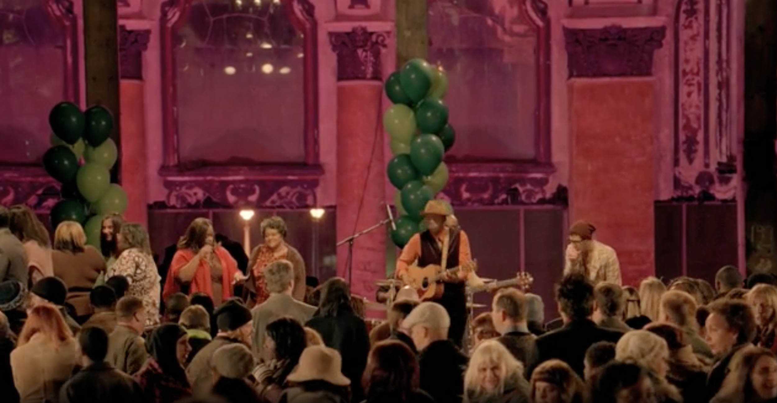 Person wearing glasses and a yellow beanie inside a subway train, with passengers seated in the background.