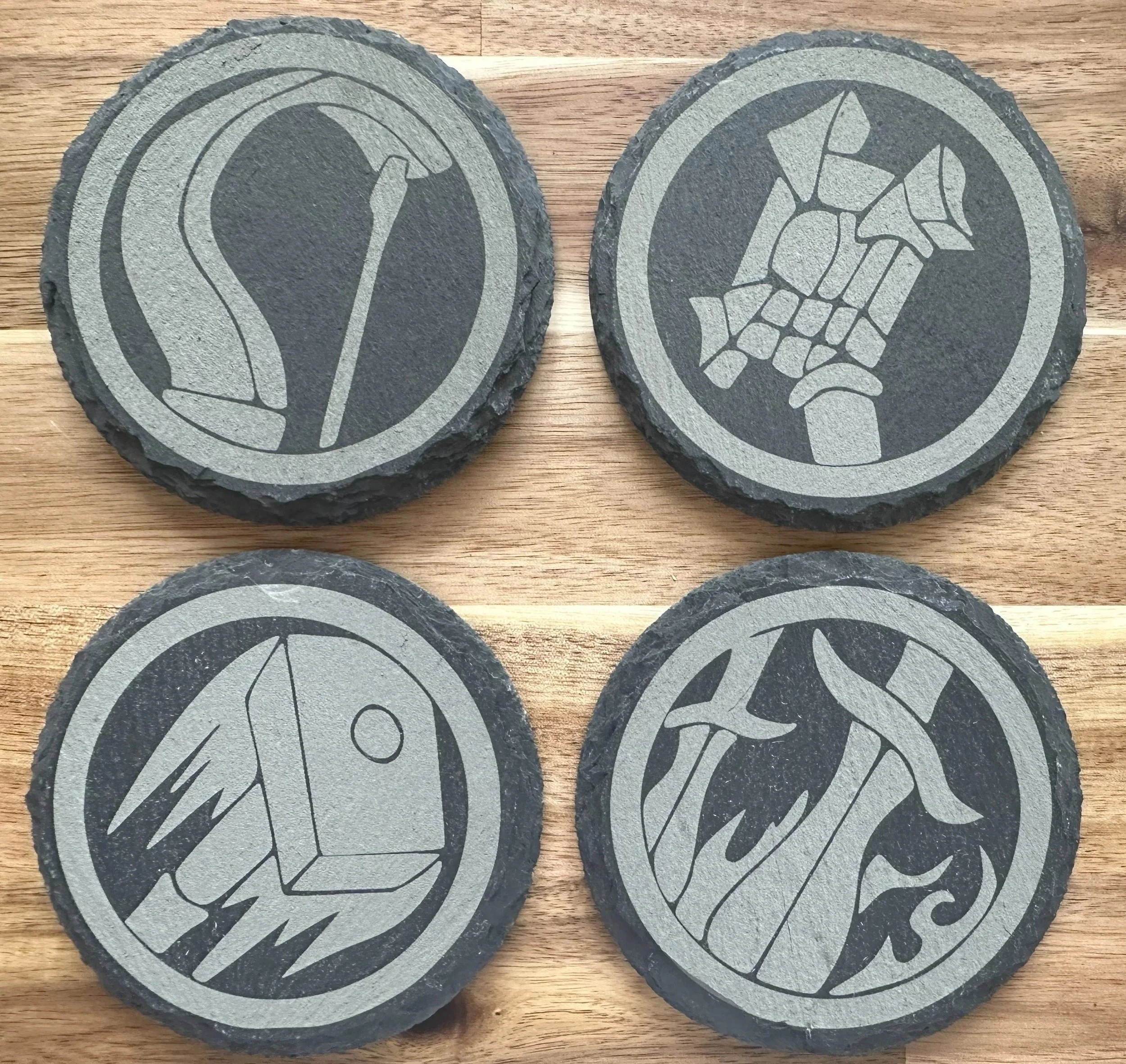 Four round slate coasters with depictions of The World of Warcraft character icons