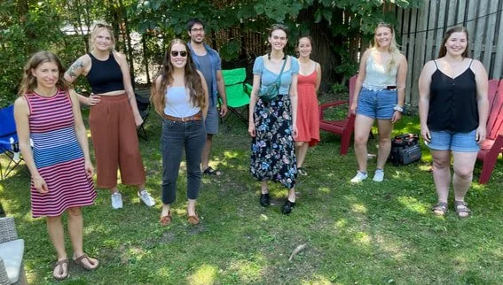 Eight lab members at a casual outdoor gathering