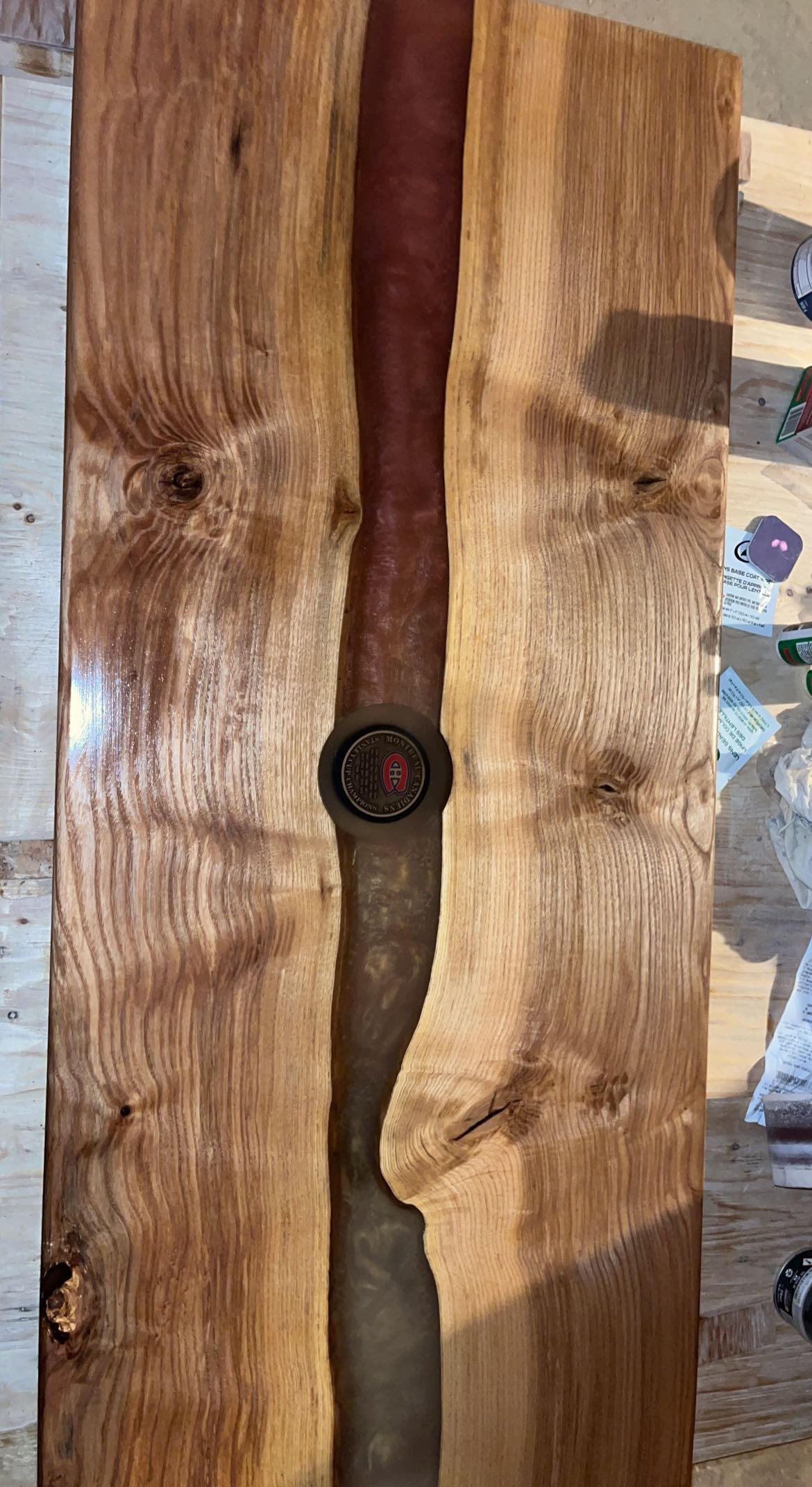 Live edge wooden table with epoxy center and embedded speaker.