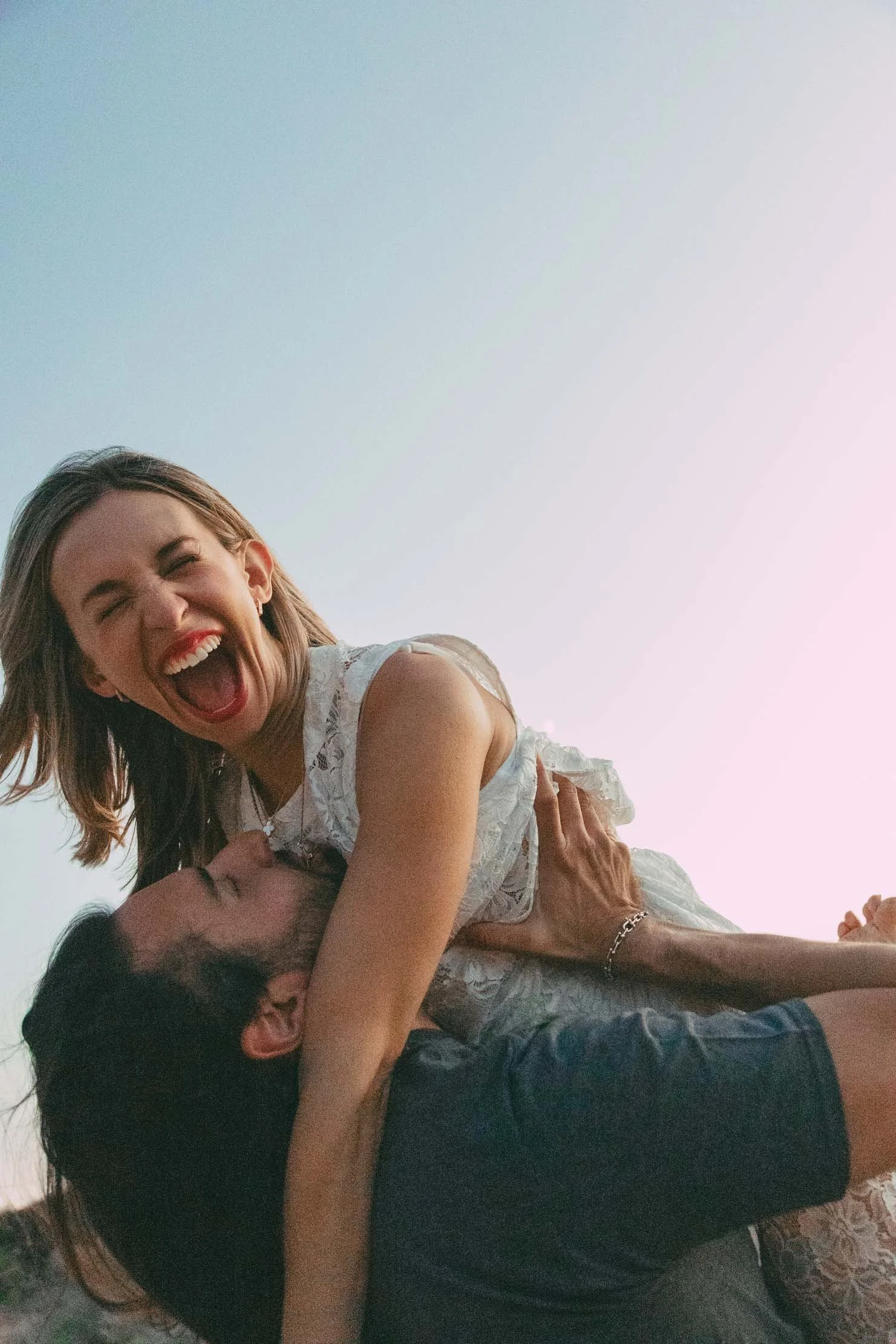 laughing-couple-on-shoulders-sunset-greece-engagement.jpg