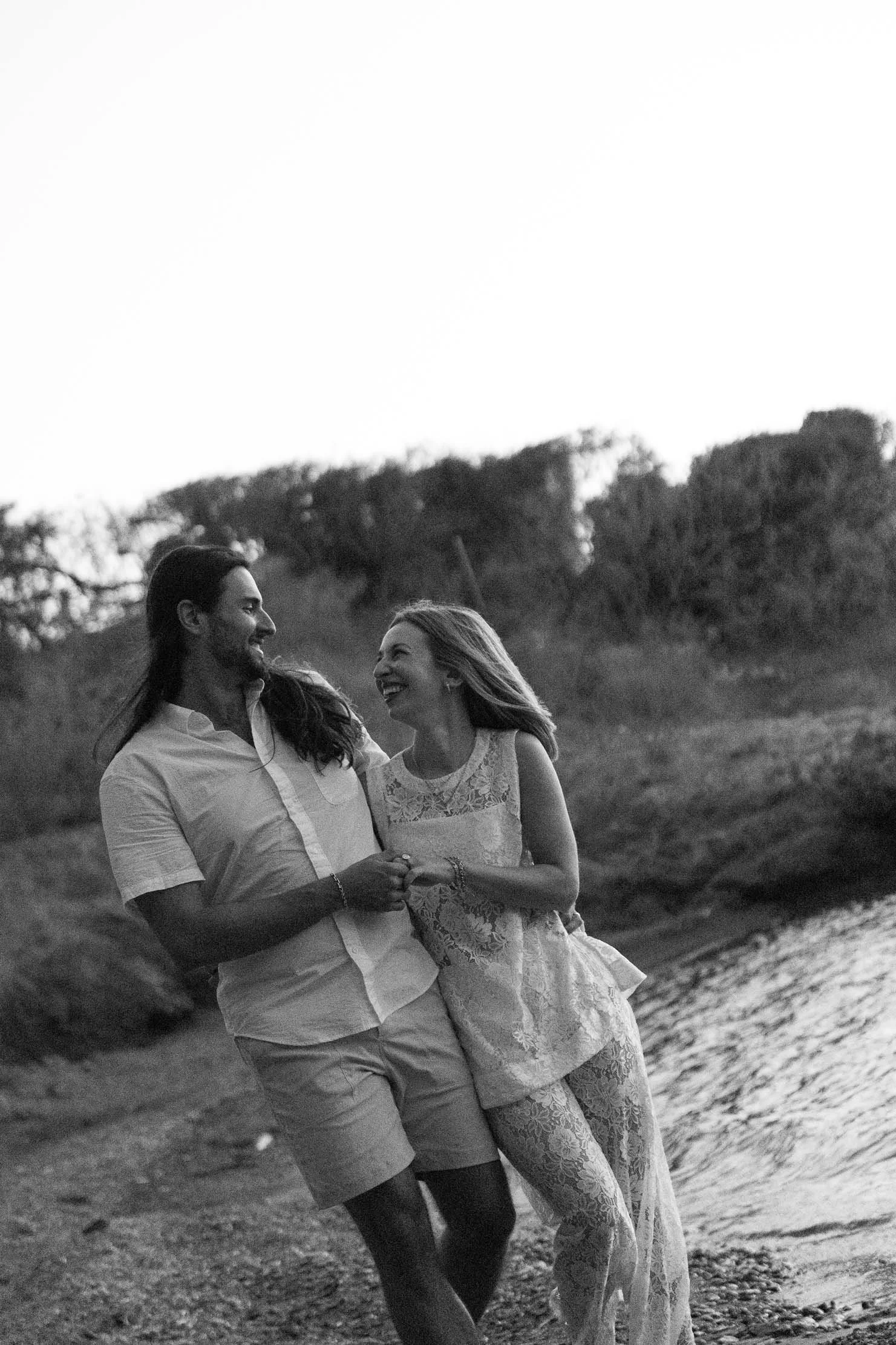 black-and-white-couple-walking-laughing-beach-greece.jpg