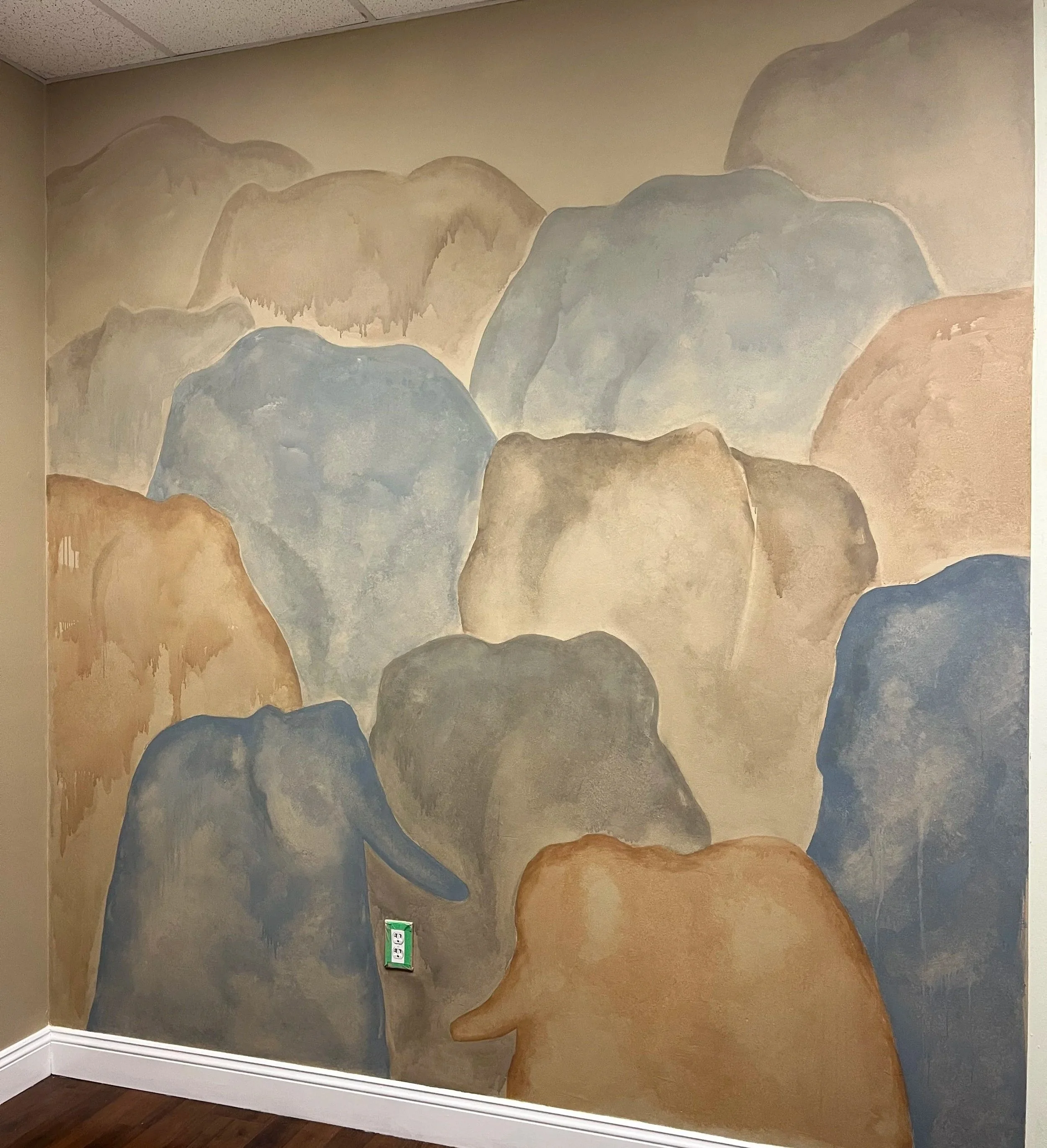 Muse&Flow Miami Art Services Commission Artist Patricia Machin book an artist Wall mural painting of mountain landscape with various shades of brown, gray, and blue, shaped as elephant