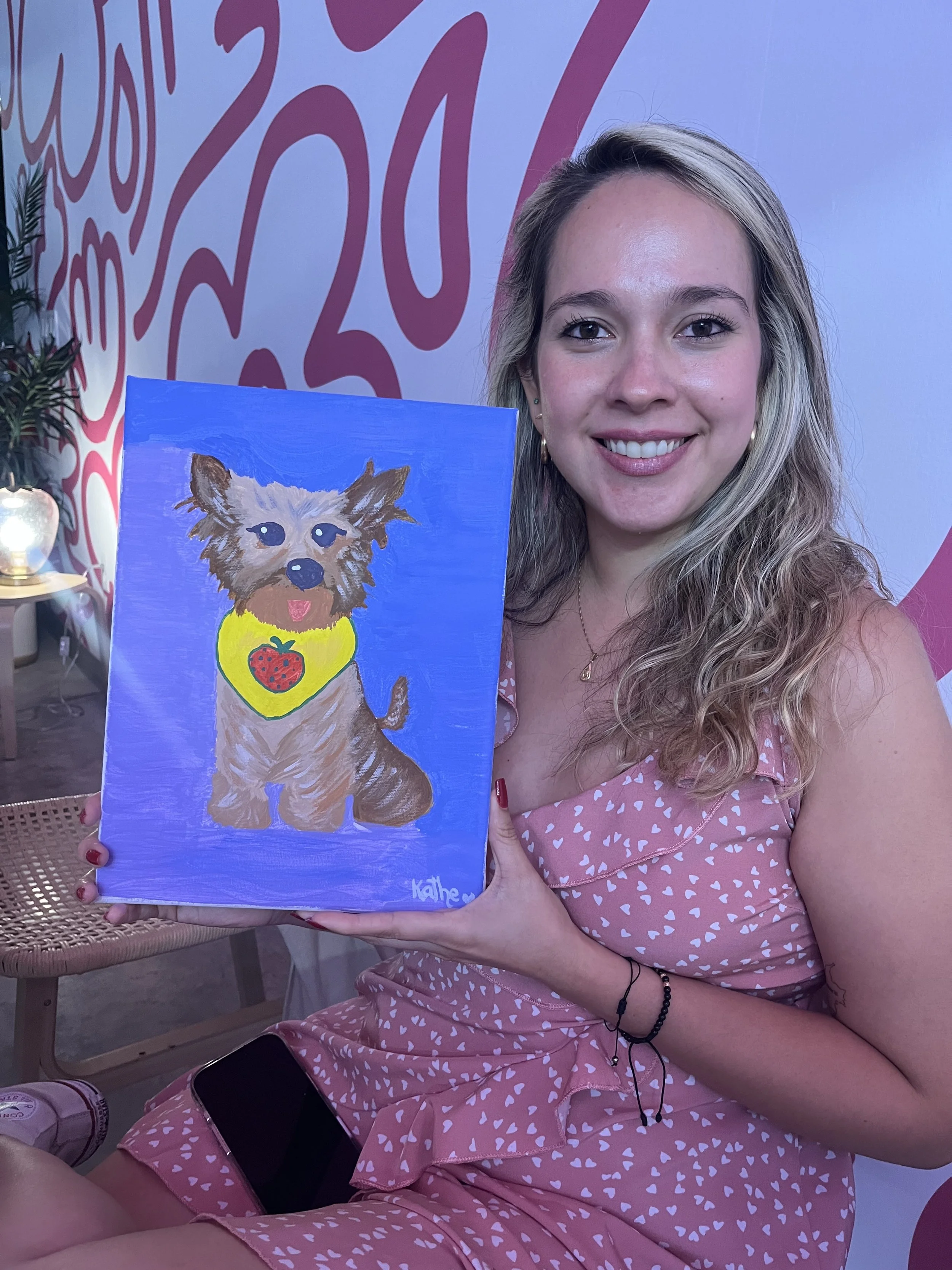 Muse&Flow Miami group paint party custom handmade canvas classes for kids best ideas creative activities birthday bachelorette corporate team woman smiling and holding art of puppy in Boni Bakery Wynwood