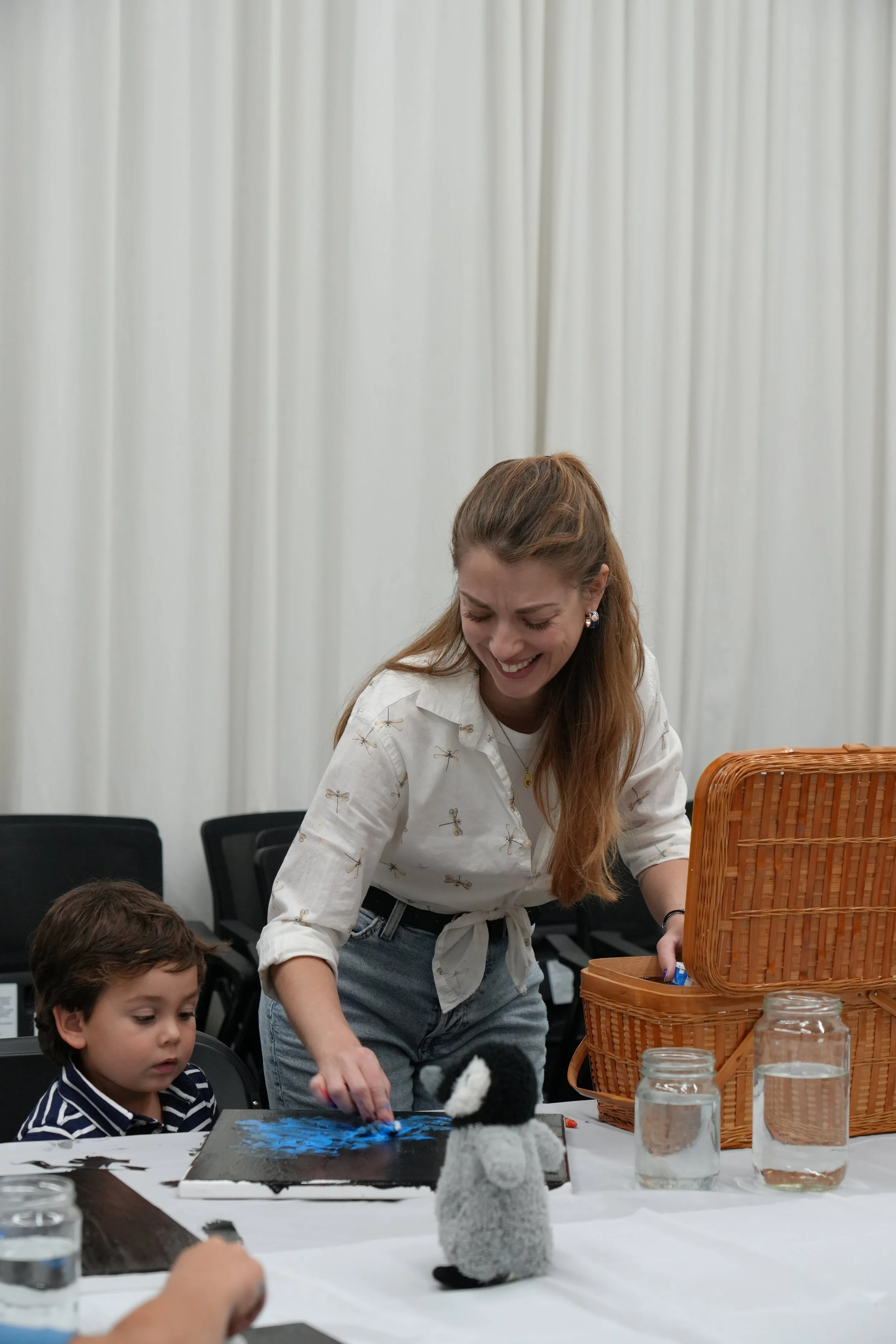 Muse&Flow Miami group custom handmade paint classes for kids best ideas creative activities corporate team building art workshop. A woman and two young children at a table with painting supplies.