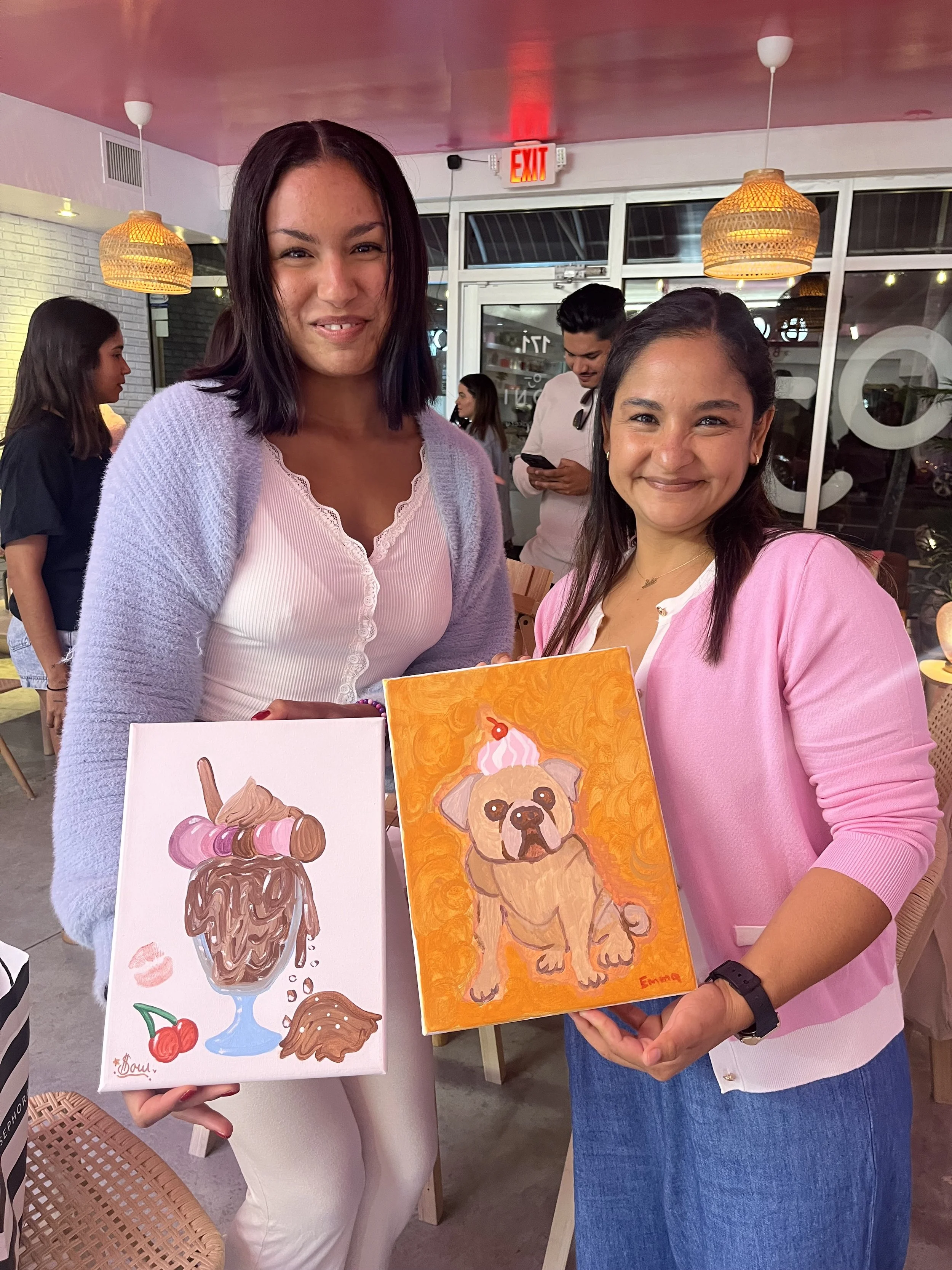 Muse&Flow Miami group paint party custom handmade canvas classes for kids best ideas creative activities birthday bachelorette corporate team women smiling and holding art of desserts and dogs in Boni Bakery Wynwood