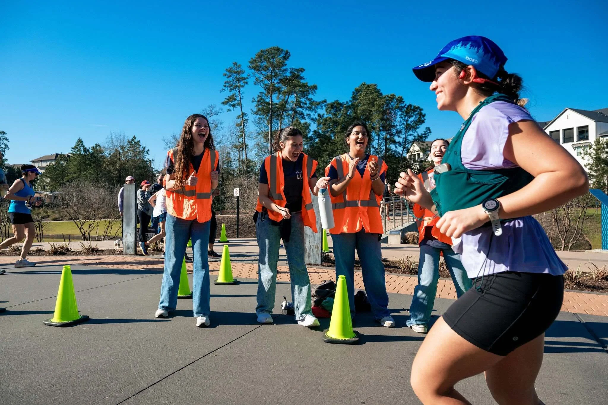A course-side team cheering enthusiastically for a runner