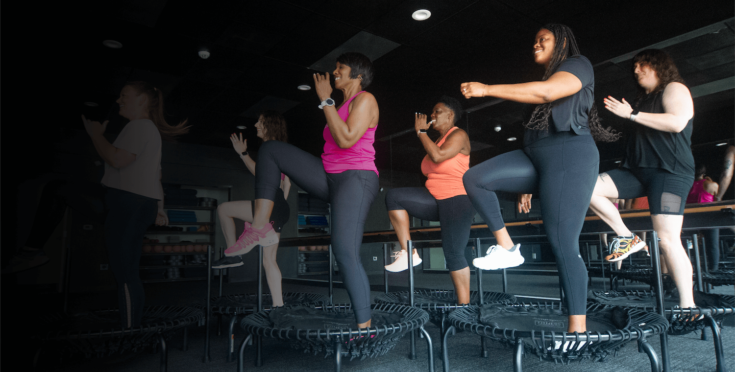 A high-energy rebounding fitness class at 901FitLife in Memphis, featuring women performing synchronized cardio on mini-trampolines.