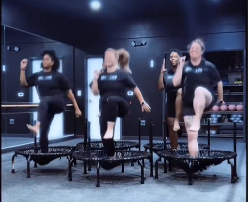 A high-energy rebounding fitness class at 901FitLife in Memphis, featuring women performing synchronized cardio on mini-trampolines.