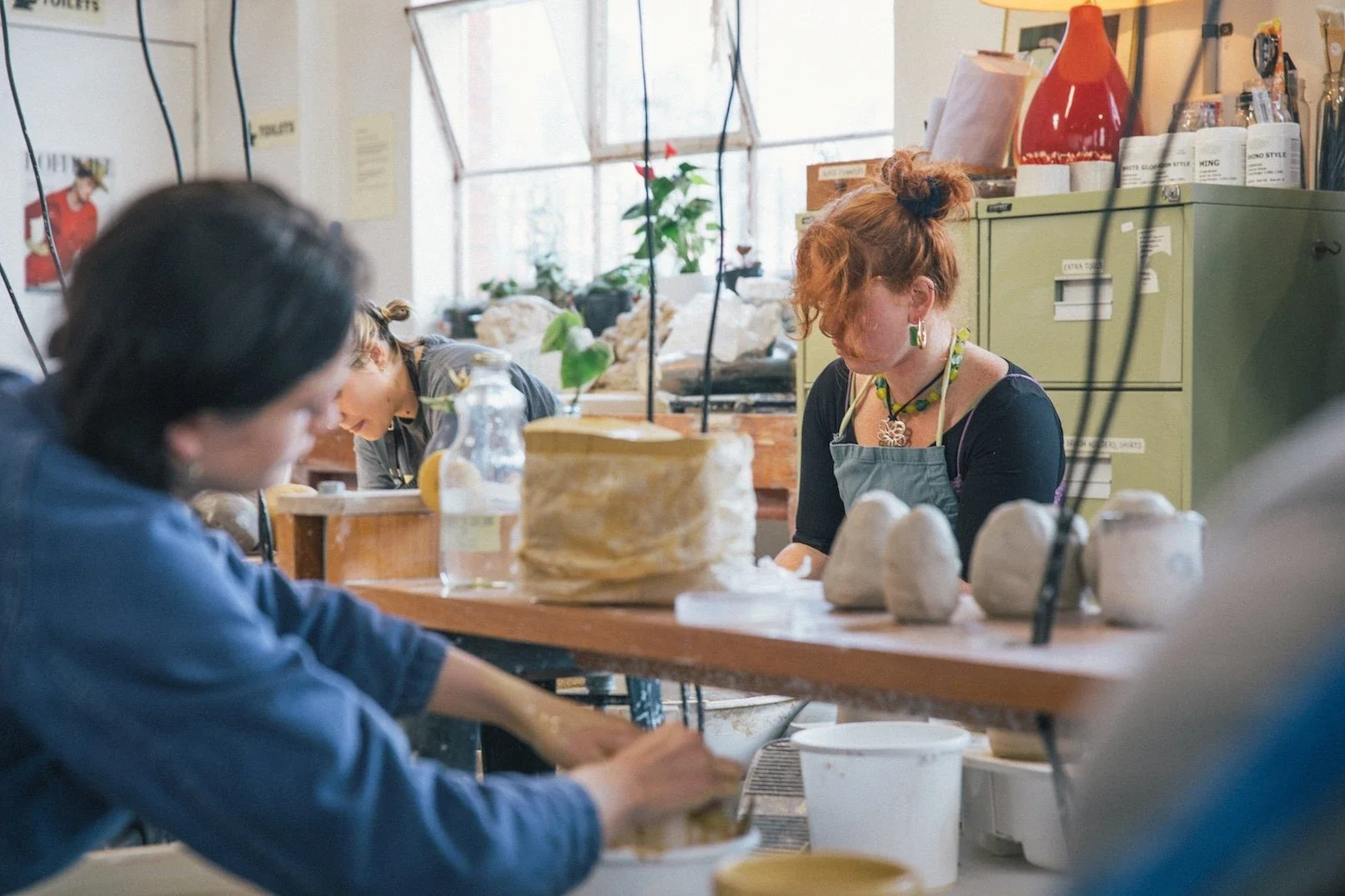 Makers working with clay together at a shared table in the Mayfield pottery studio in Abbotsford, Melbourne