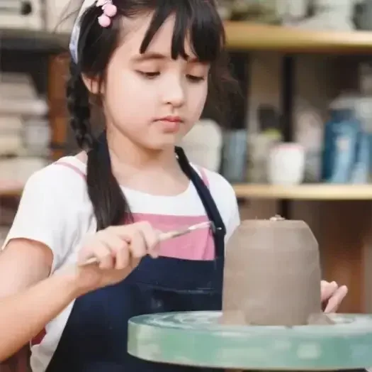Child painting pottery at Mayfield Studios Kid's Club