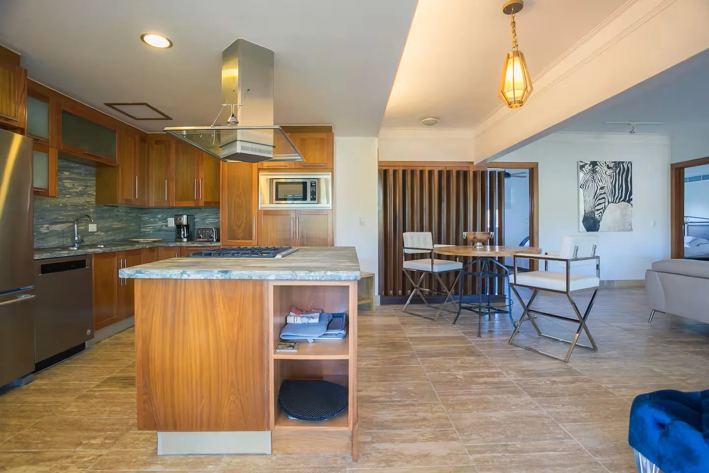 Interior de una cocina y comedor en un estilo moderno con muebles de madera y suelo de baldosas de cerámica.