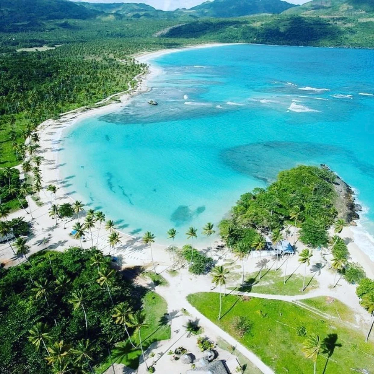 Aerial view of a scenic coastline with cliffs and turquoise ocean waters.