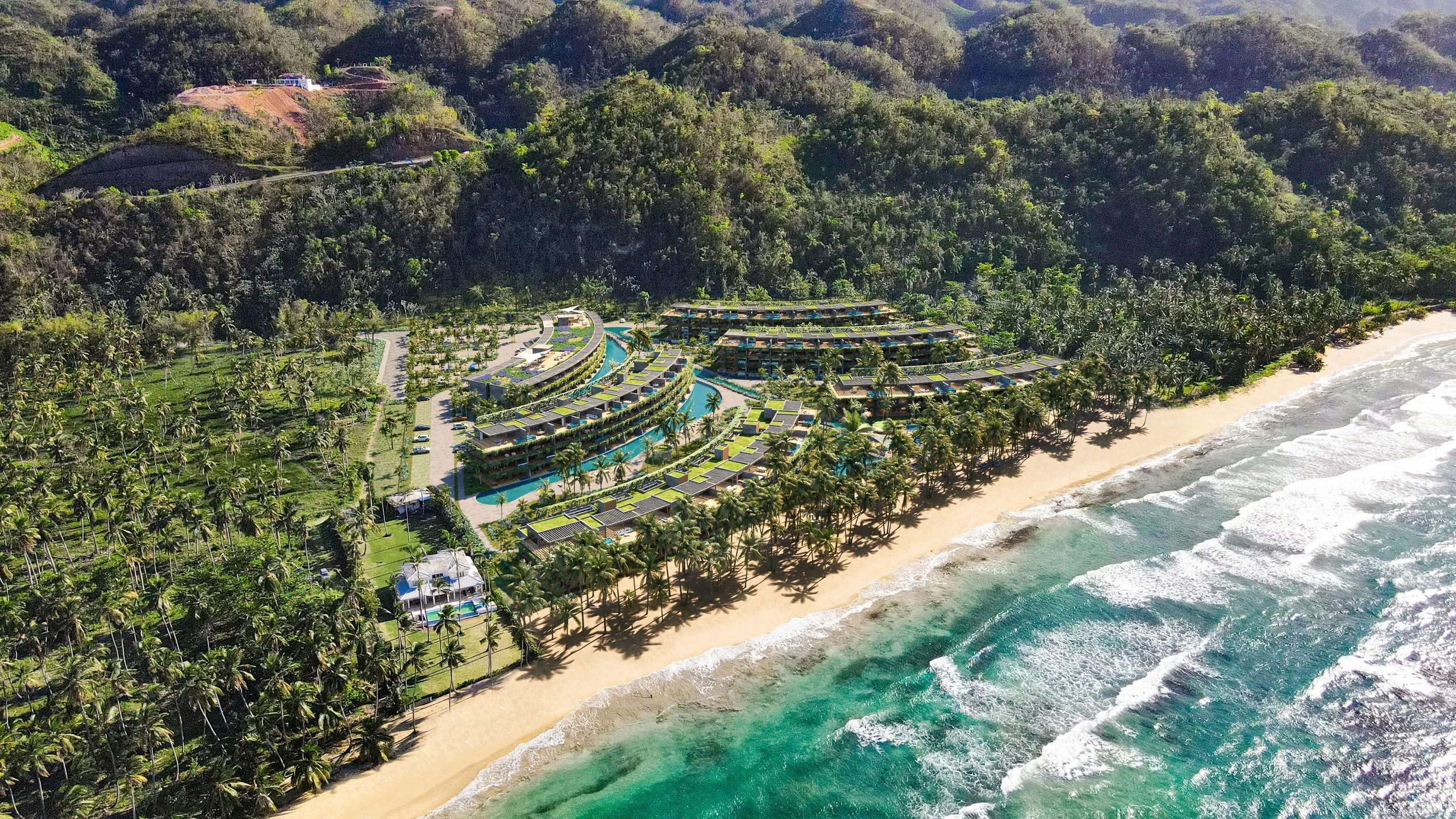 Vista aérea de un complejo turístico frente a la playa con muchas palmeras, estructuras modernas con piscinas y un área verde rodeada de montañas misteriosas cubiertas de vegetación.