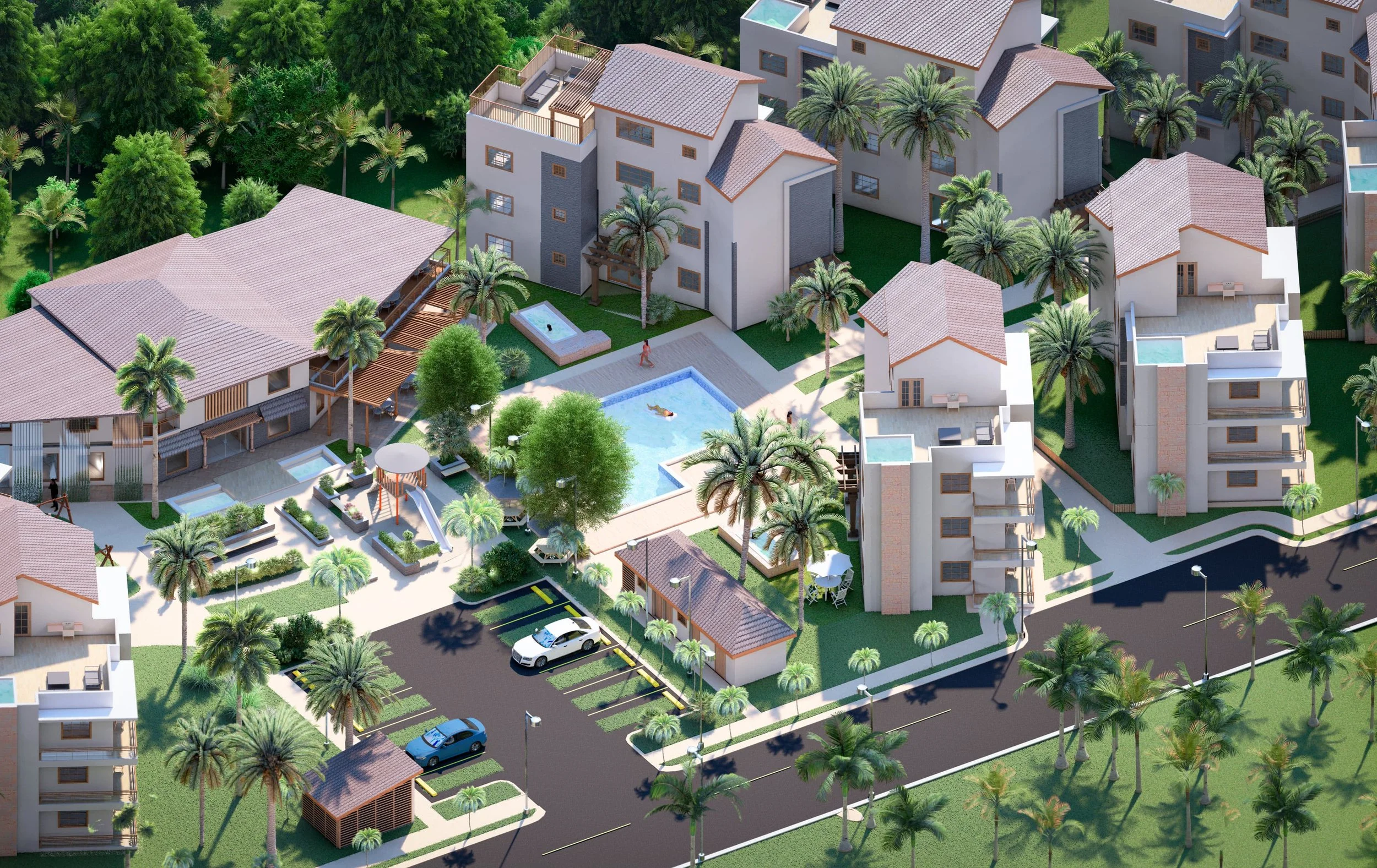 Vista aérea de una comunidad residencial con edificios blancos, palmeras, piscina, áreas verdes y estacionamiento.