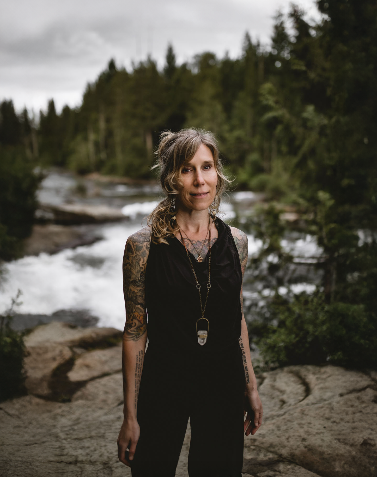 Portrait of Natalie Rousseau standing by a river in the forest.