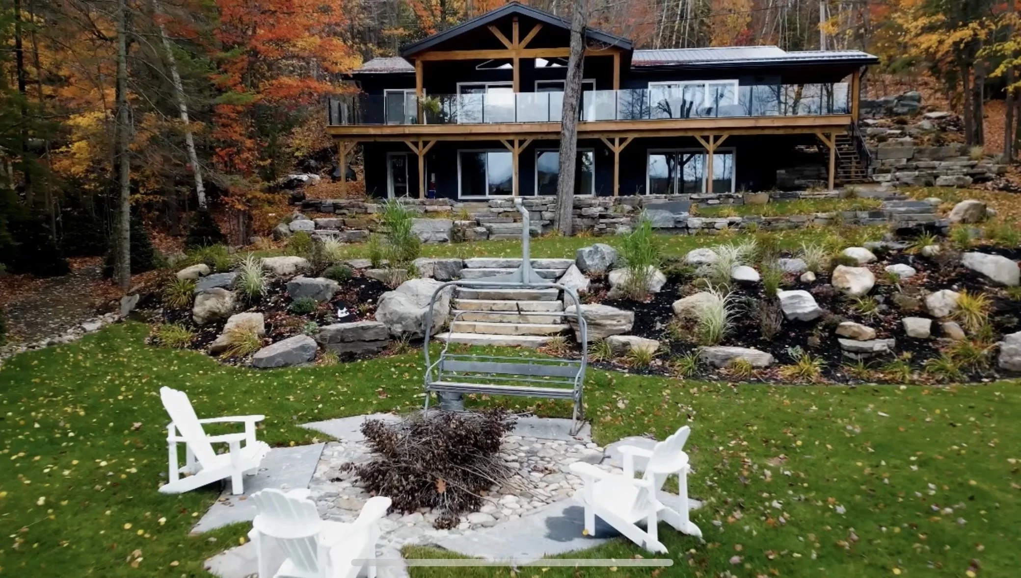 Fire burning logs in a fire pit surrounded by stone paving.