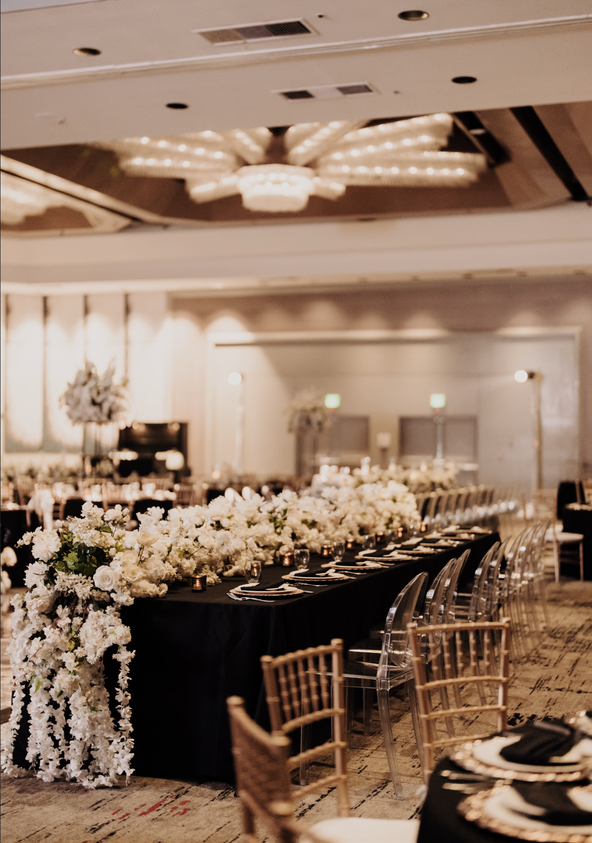 A long black-clothed table set for a celebration