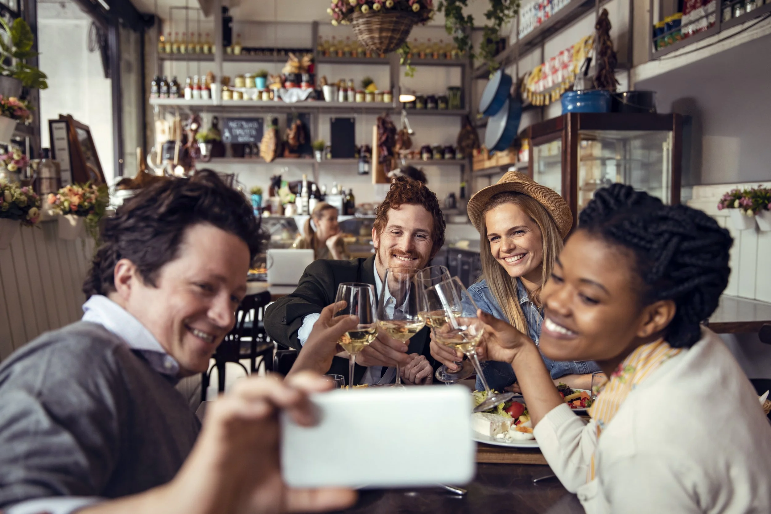 Group of friends enjoying drinks and taking a selfie at a restaurant