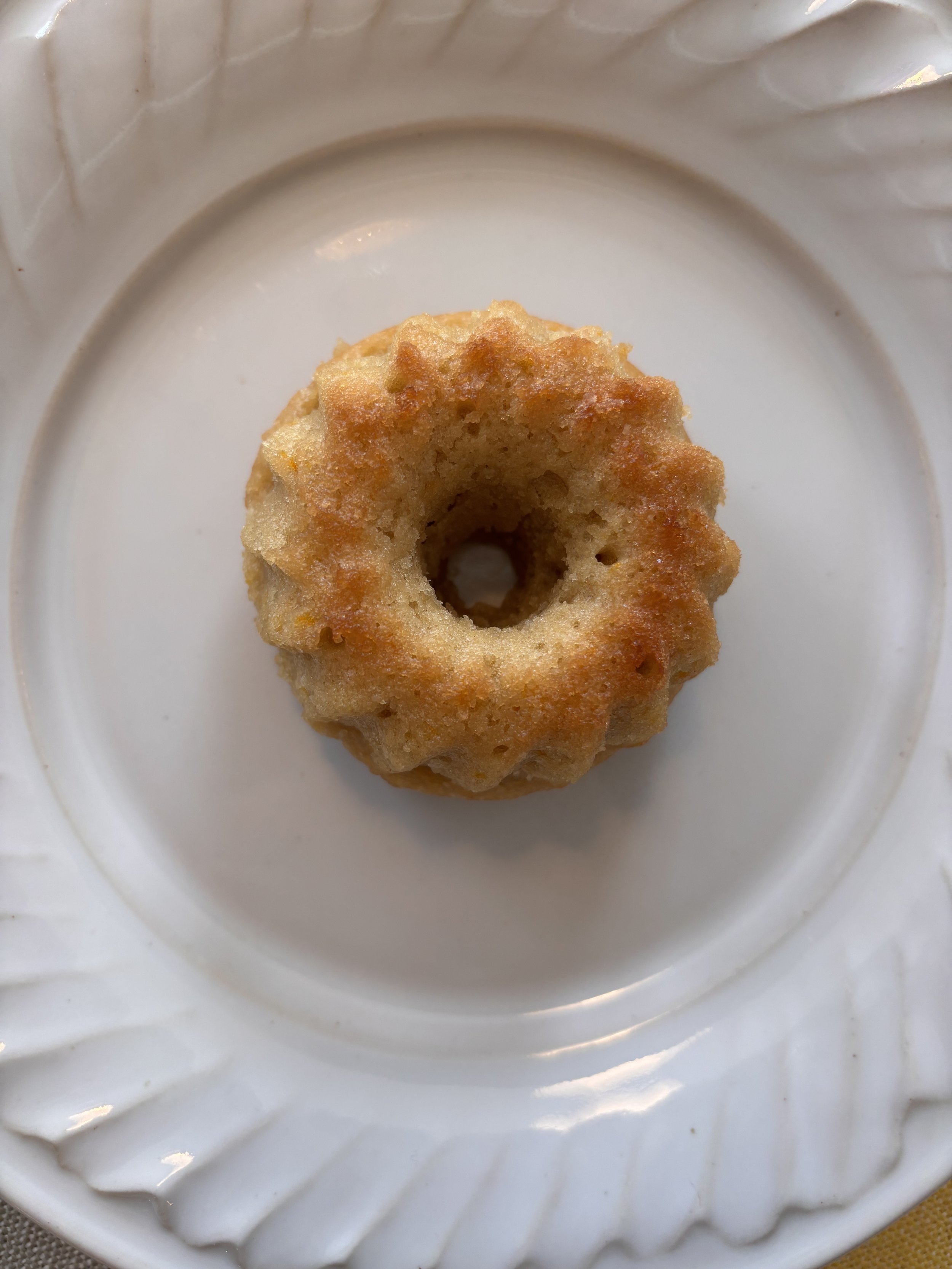 Close-up of mini citrus tea bundt cake on a scalloped plate
