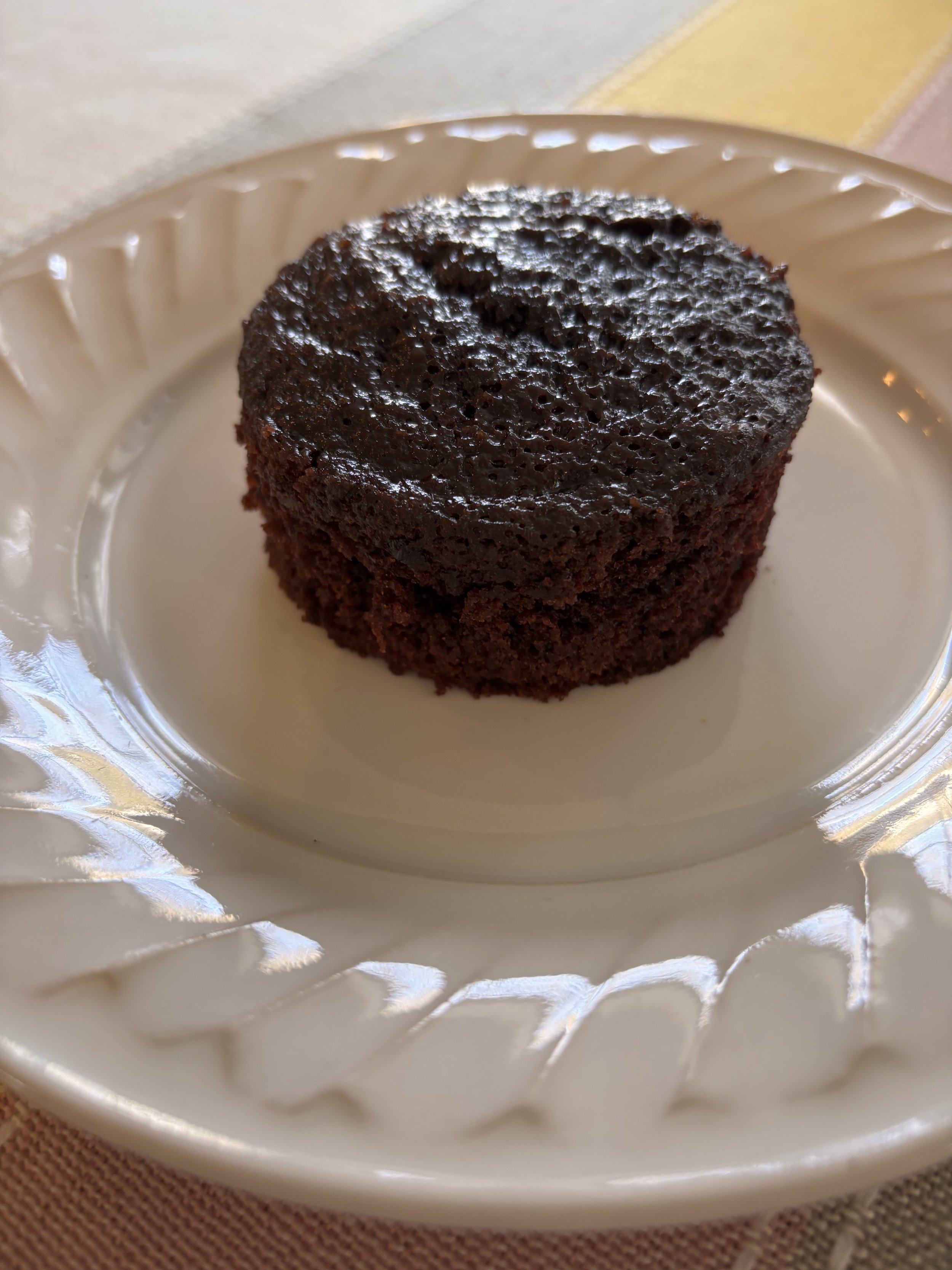 Close-up of a 3-inch chocolate cake on a scalloped plate