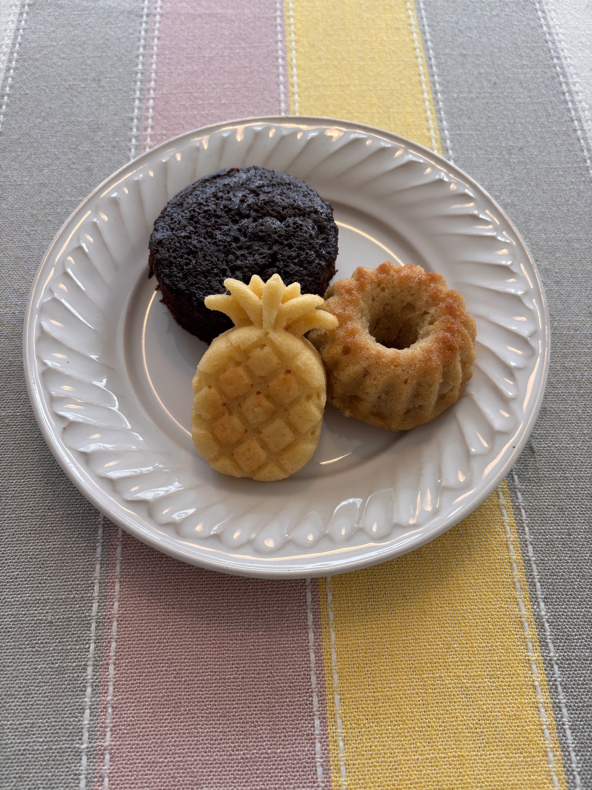 Mini chocolate cake, citrus tea cake, and tropical rum cake on a scalloped plate