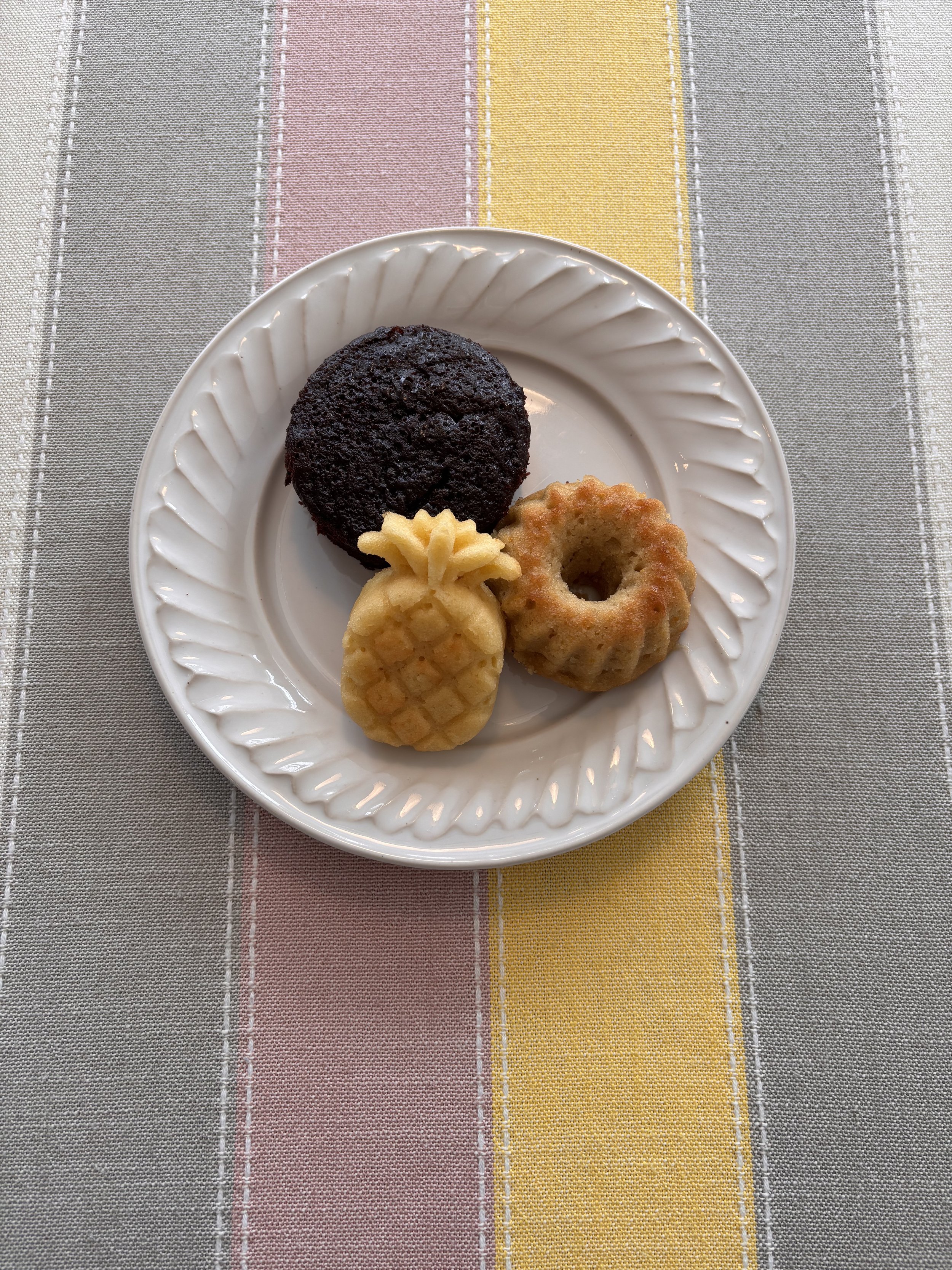 Mini chocolate cake, citrus tea cake, and tropical rum cake on a scalloped plate