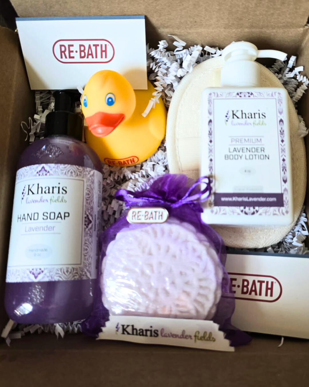 lavender bath products and a yellow rubber duck in a gift box