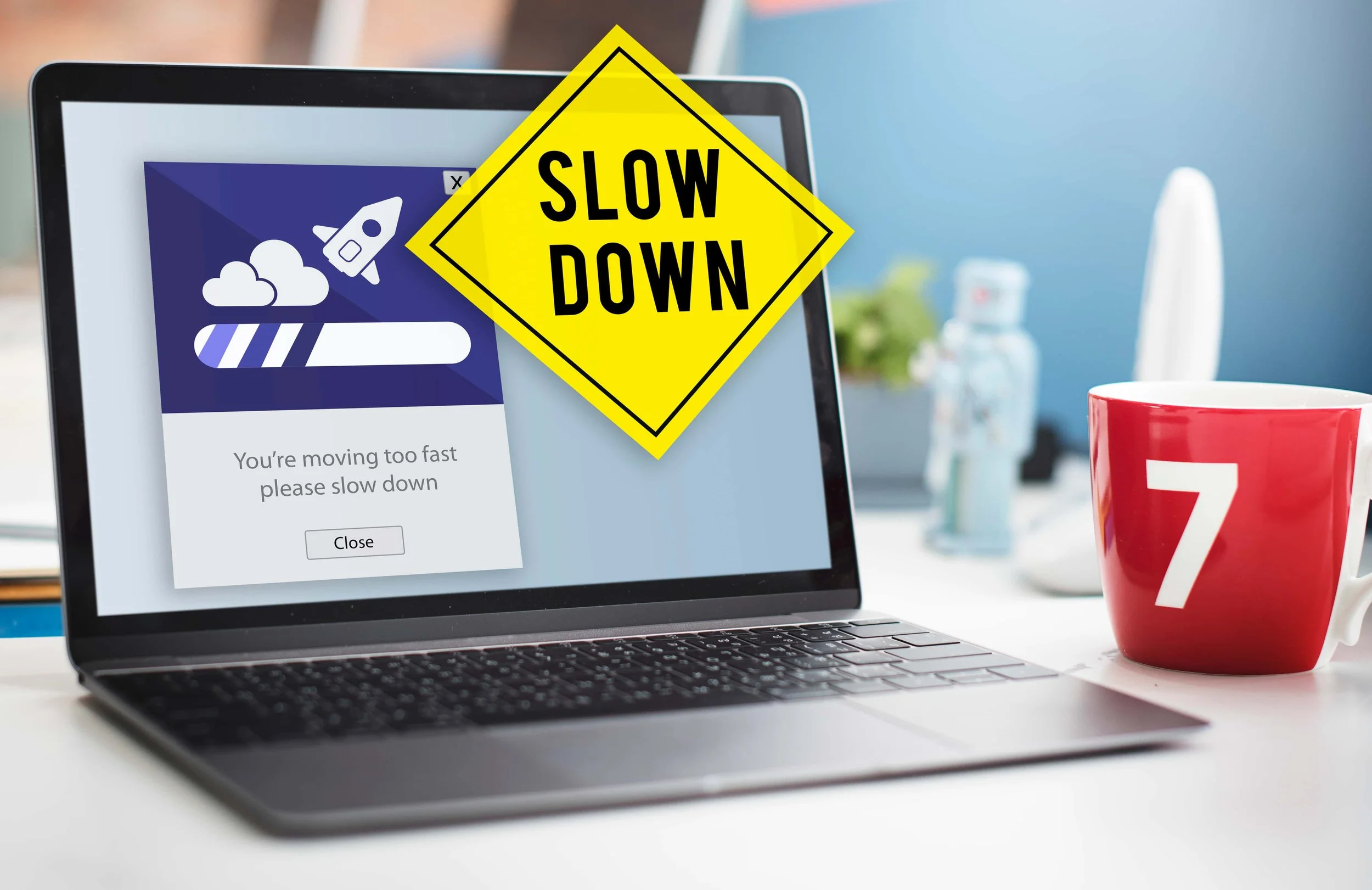 Laptop with a loading graphic and a Slow Down sign illustrating a slow Squarespace website