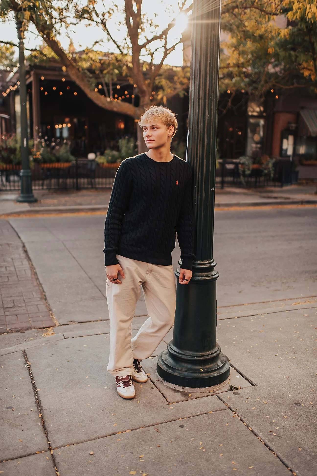 Male high school senior leaning against a brick wall with fall ivy in downtown Boise, Idaho senior photography