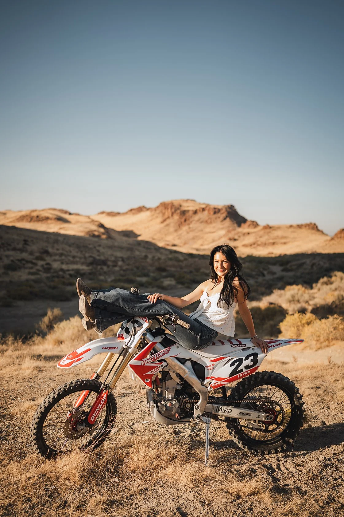 High school senior girl sitting on a dirt bike in the Idaho desert hills, Treasure Valley senior photographer