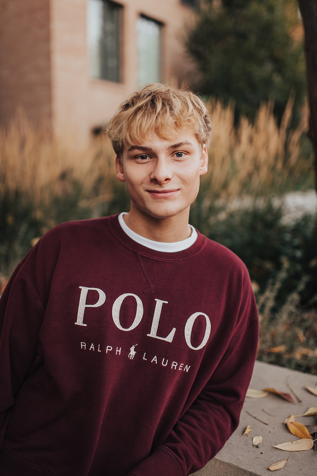 High school senior offering a small, natural smile during a comfortable senior photo session in Boise, Idaho.