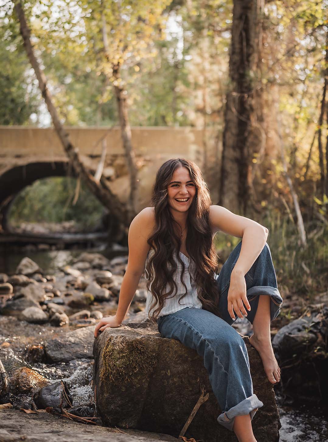 High school senior sitting casually on a rock during a relaxed senior photo session in Boise, Idaho.