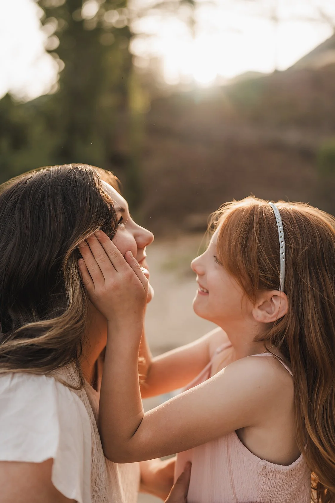 Daughter holding her mom's face during a golden hour family session