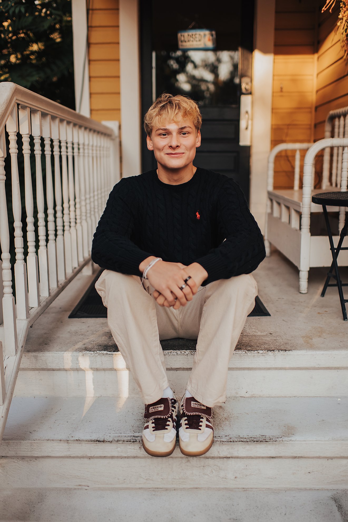 High school senior sitting comfortably on front steps during a relaxed senior photo session in Boise, Idaho.
