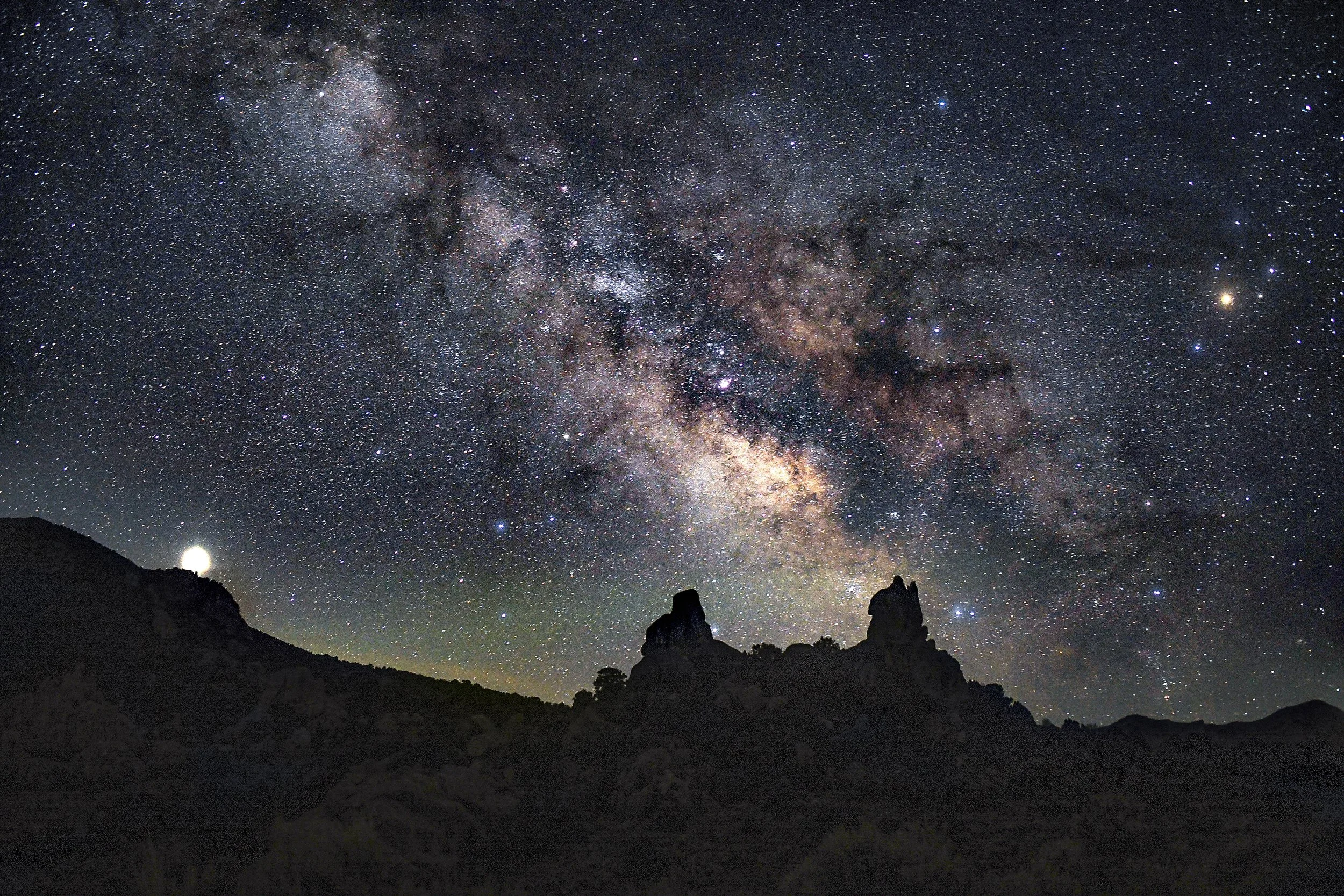 Milky Way galactic core rising over silhouetted granite spires at City of Rocks National Reserve, Idaho — astrophotography by Kim Starkey