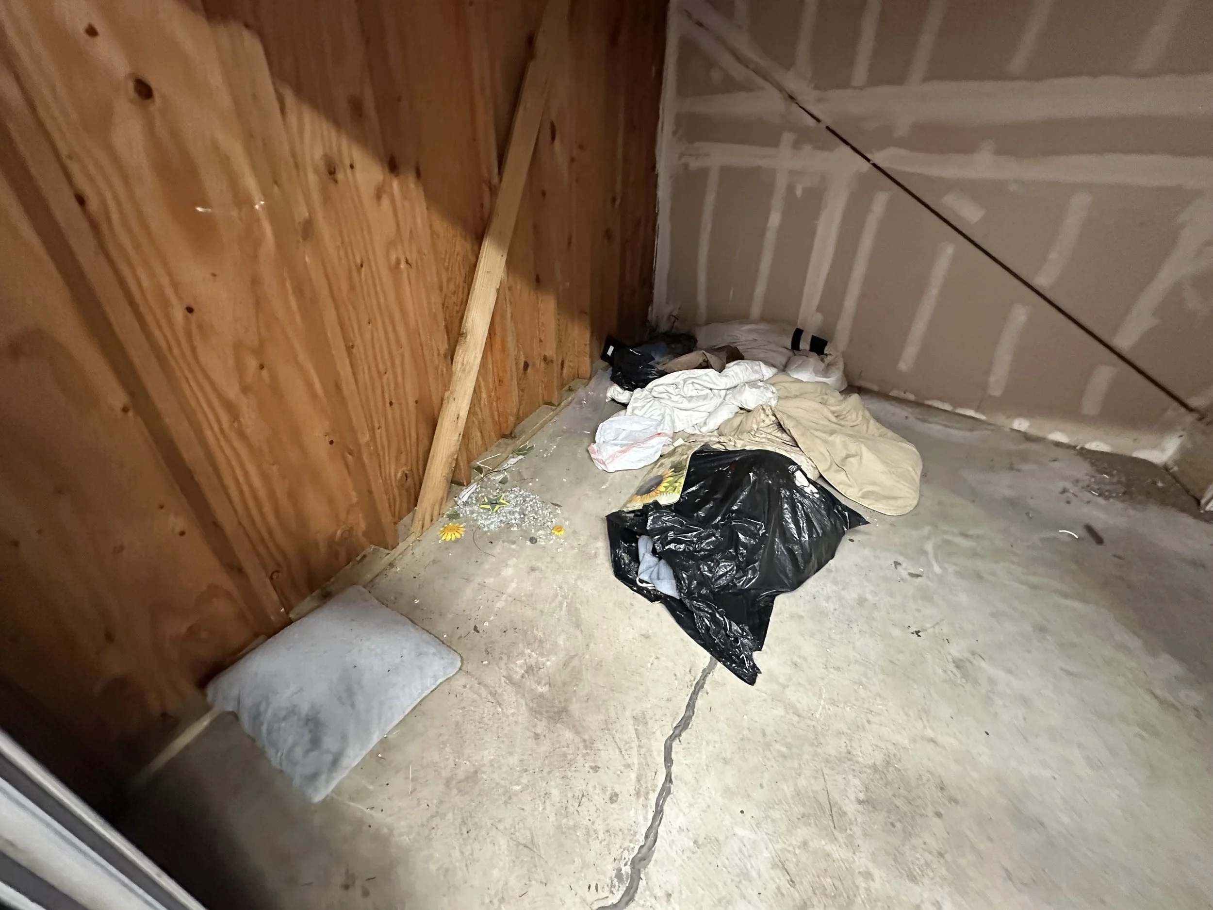 Public Storage needed a hand clearing out a unit. A trash bag along with clothes, blankets, and pillows was inside.